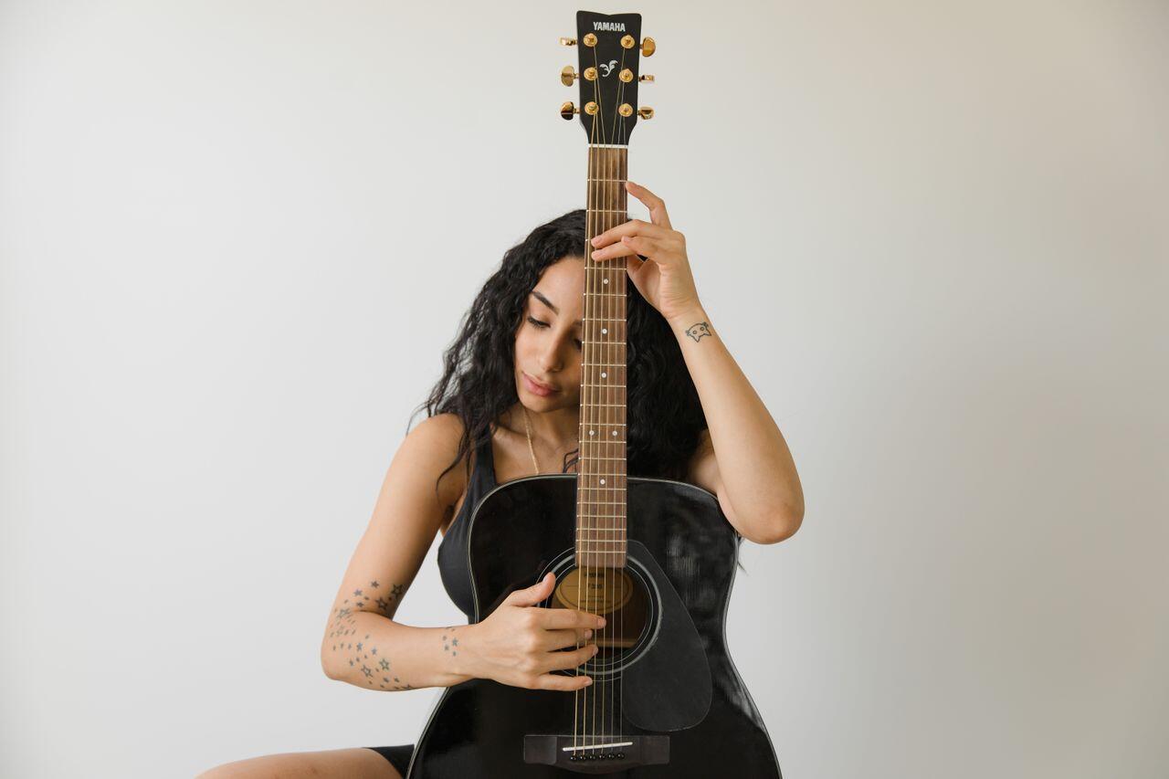 jeune femme magnifique mat avec sa guitare