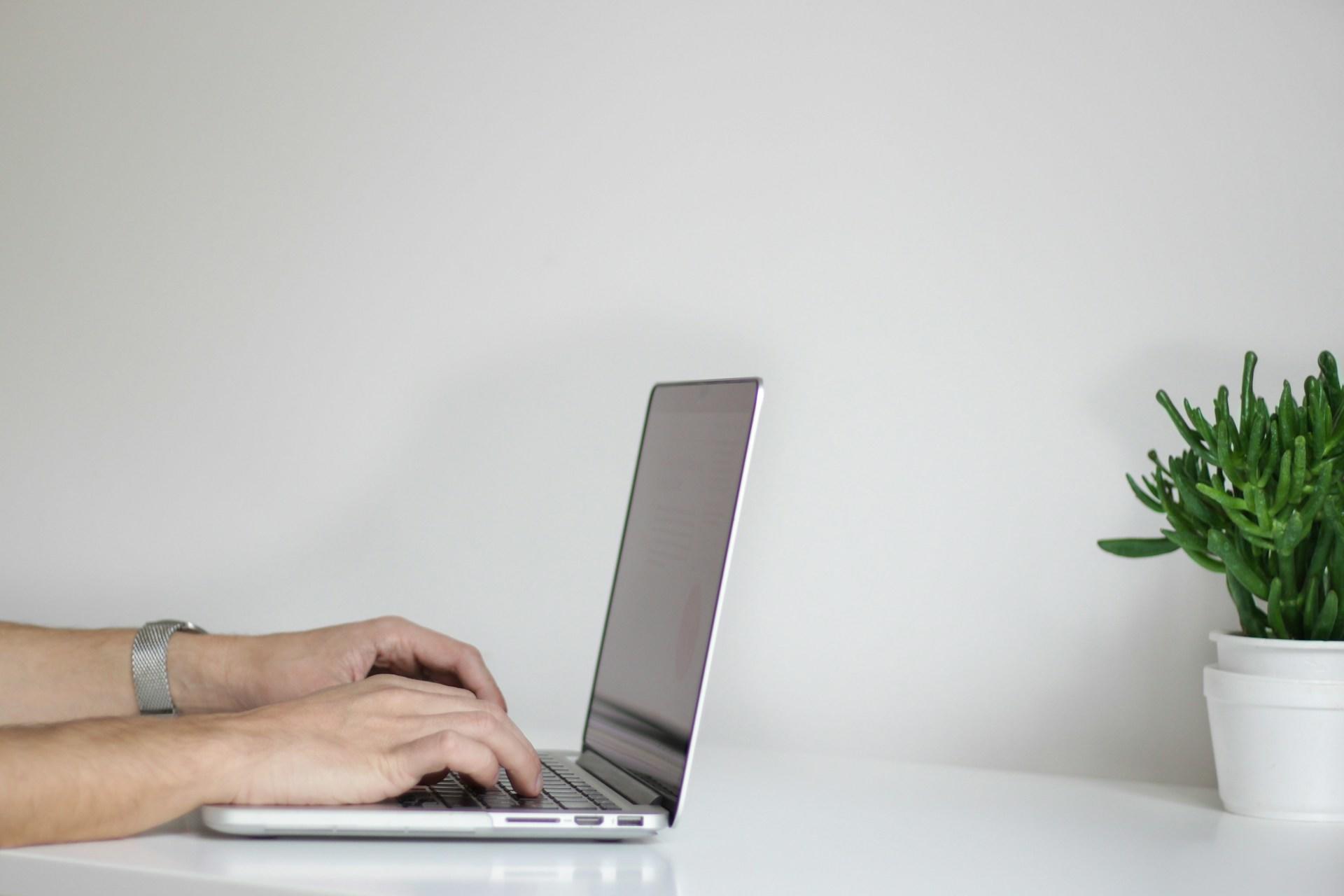 mains tapant sur un clavier d'ordinateur portable