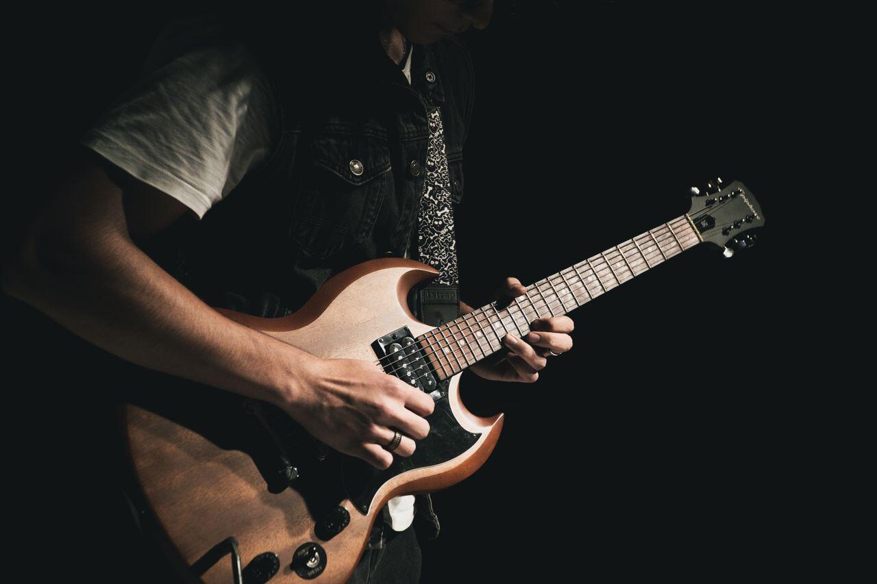 homme jouant de la guitare électrique