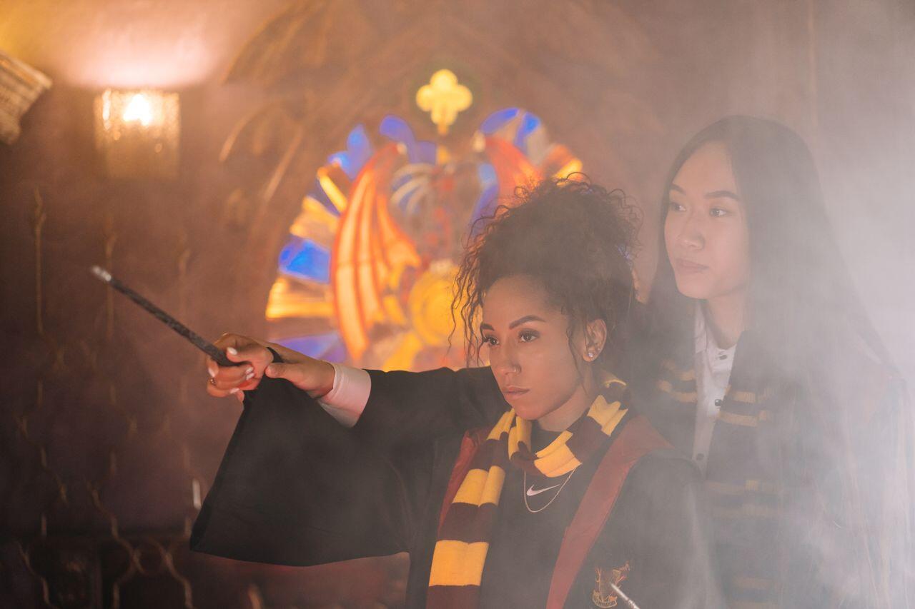 deux filles deguisees en harry potter pratiquant la magie dans un brouillard