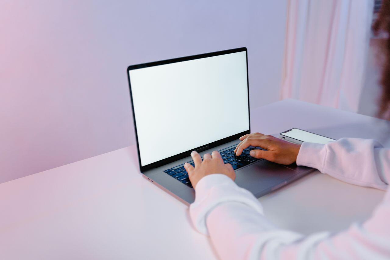 fille travaillant sur son laptop dans un fond violet
