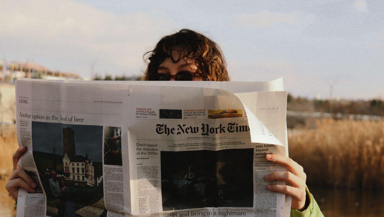 jeune femme dans les plaines lisant le new york time