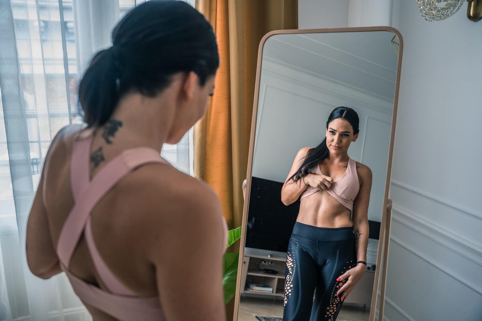 formes athlétiques sportives de femme devant miroir