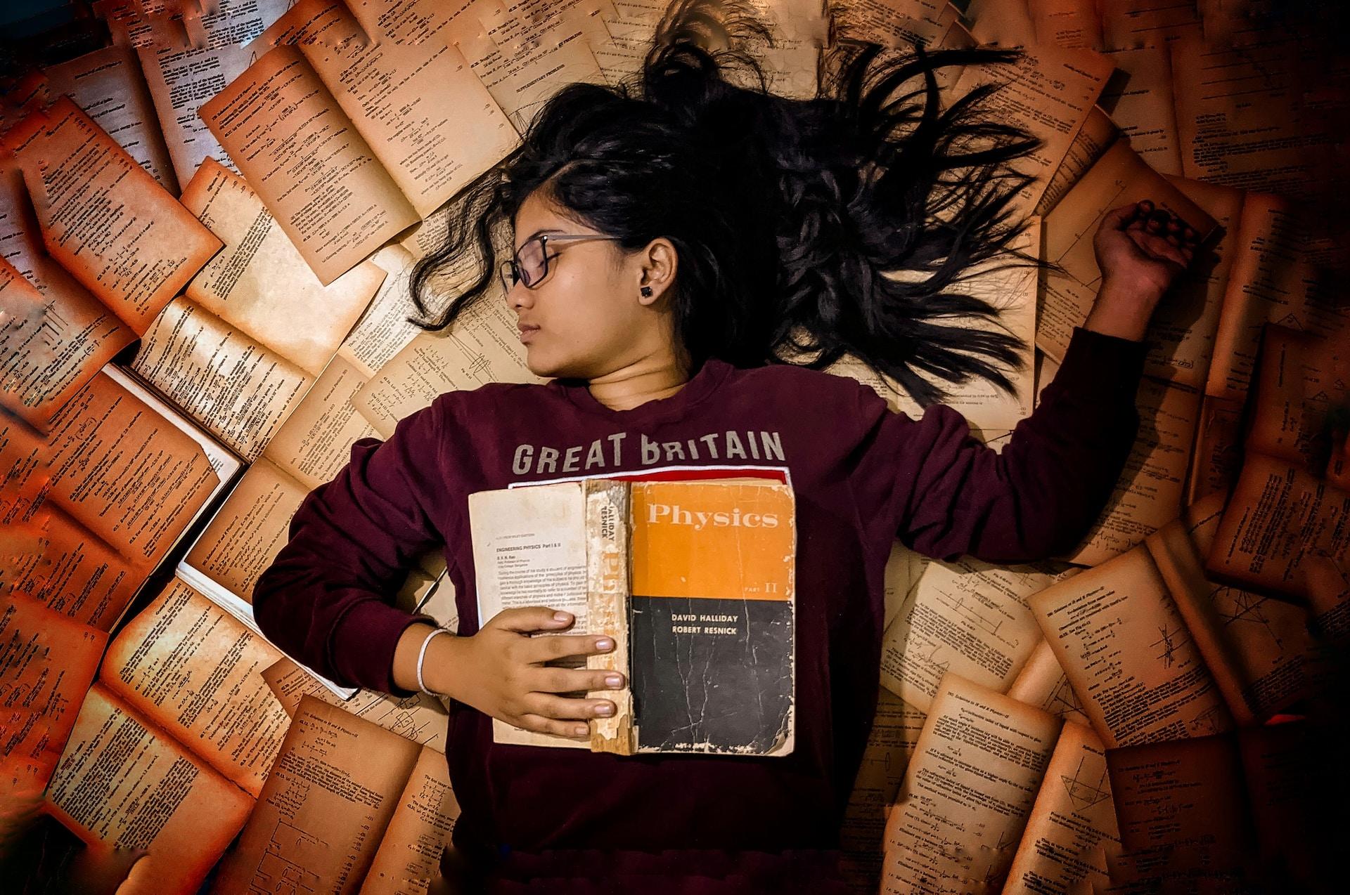 fille allongée au sol parmi des livres d'anglais