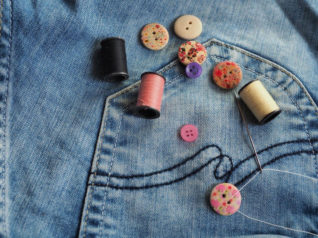 boutons et fils poses sur un jean