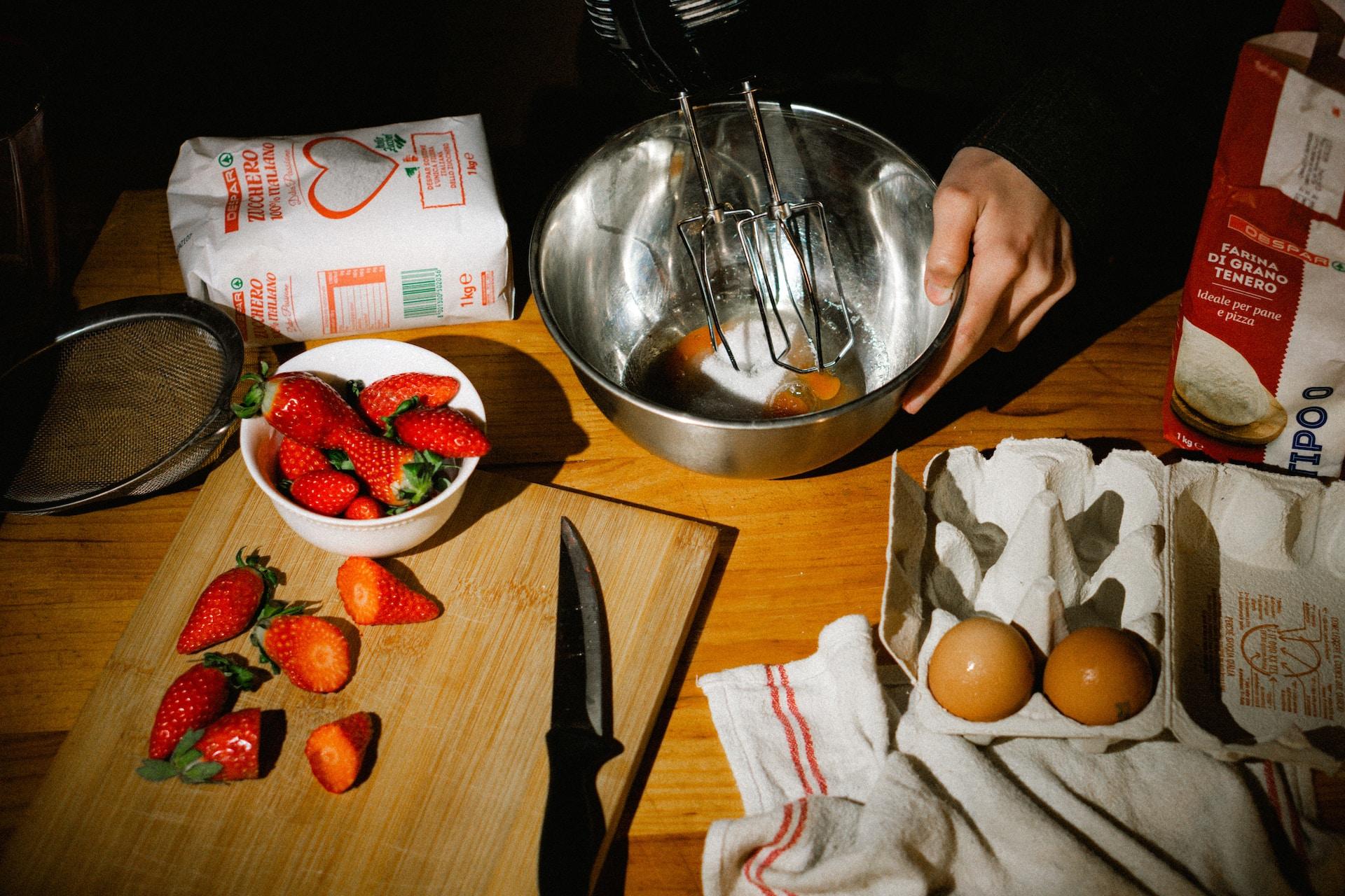 fraises et œufs avec mixeur dans une cuisine