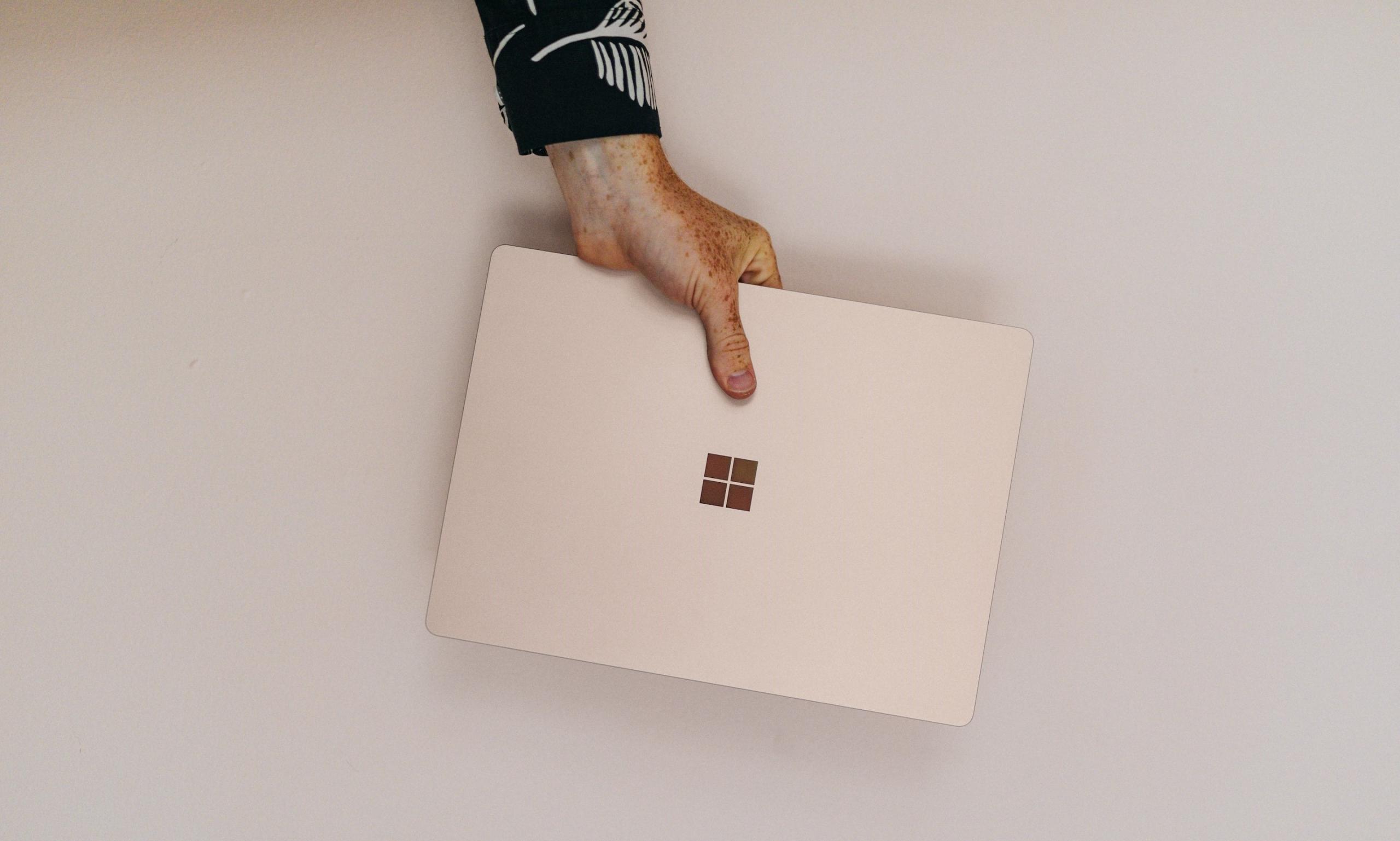 main d'homme tenant un ordinateur microsoft