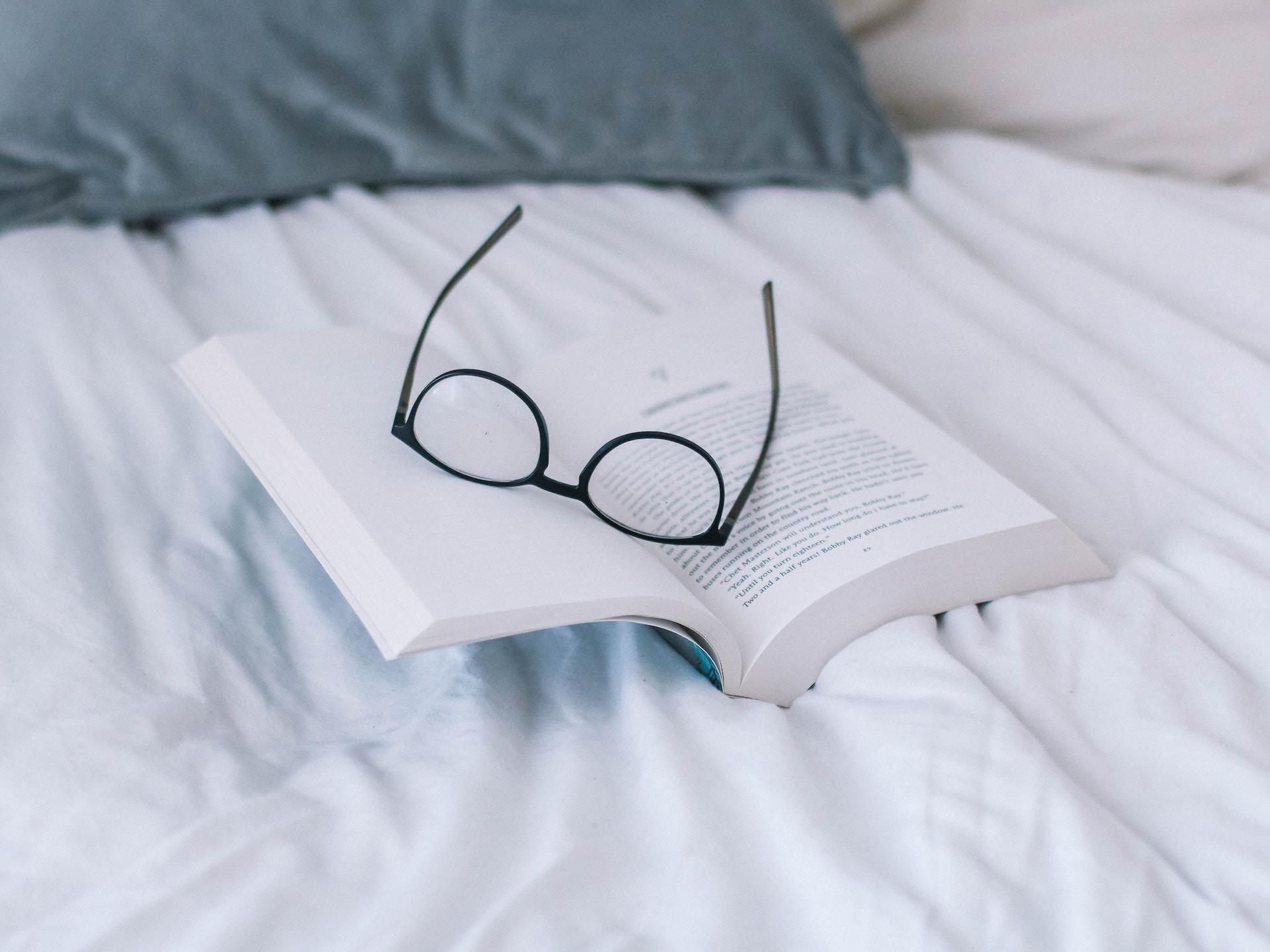 lunettes posées sur un lit pour lire