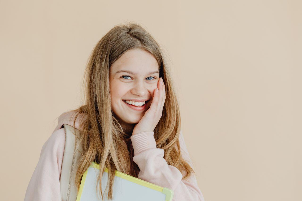 ado blonde foncee avec un grand sourire