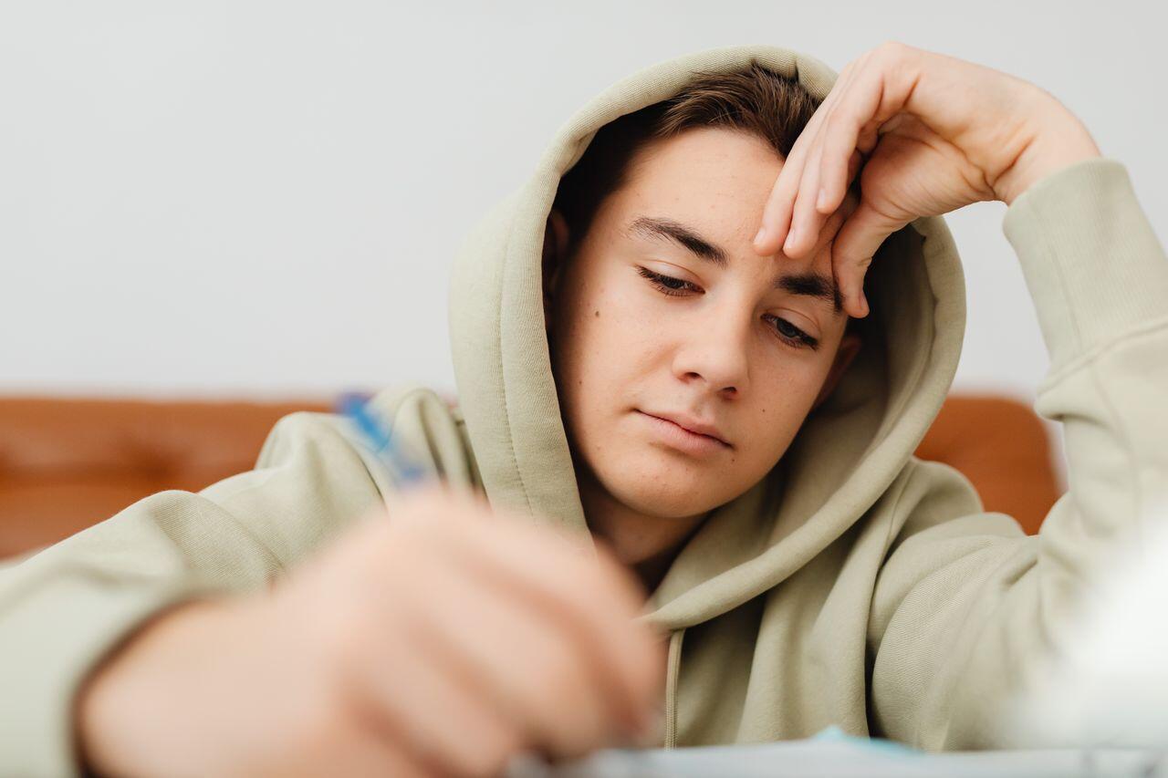 ado en capuche etudiant sur son canape