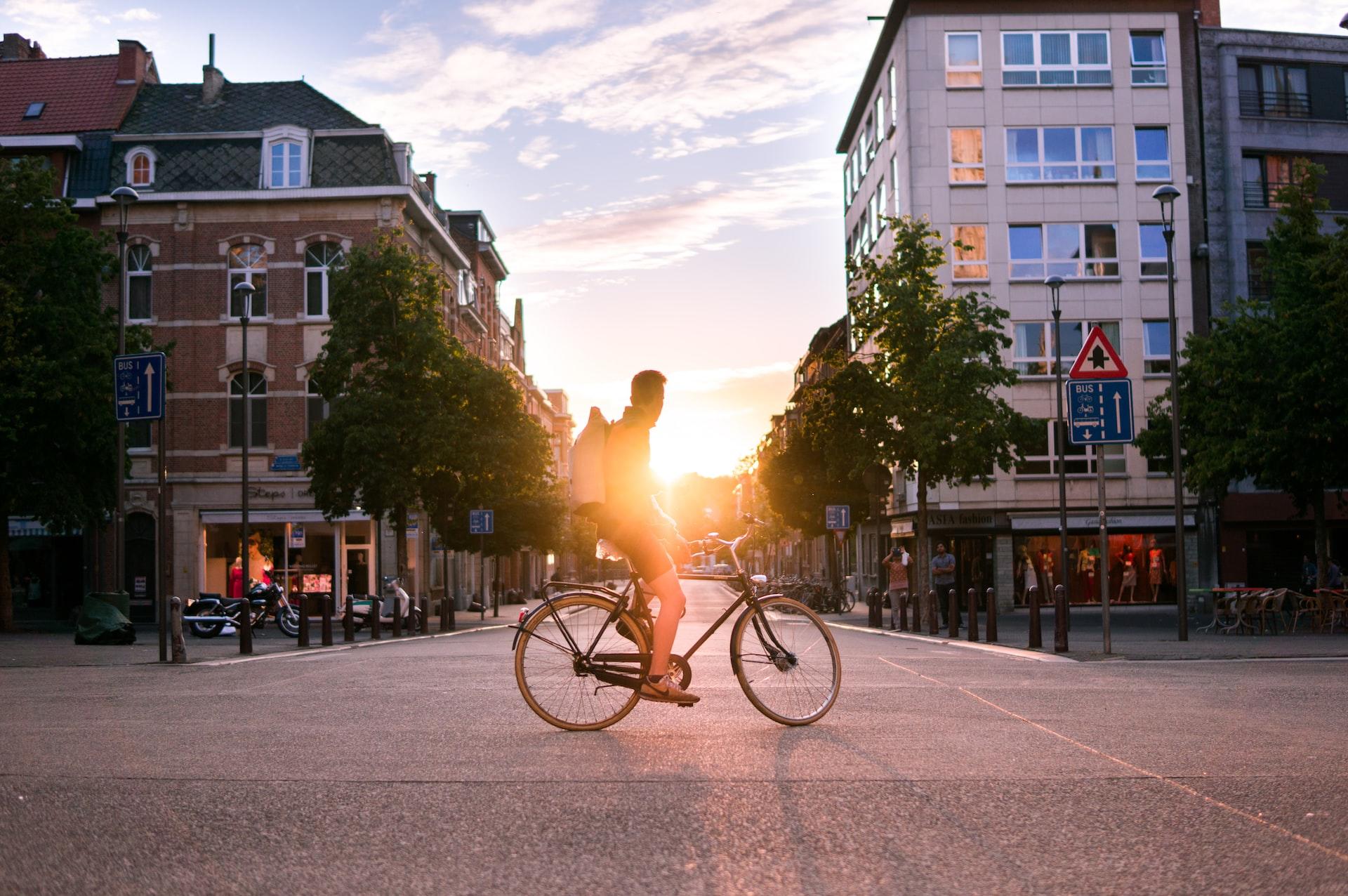 homme avec son velo au soleil couchant a louvain