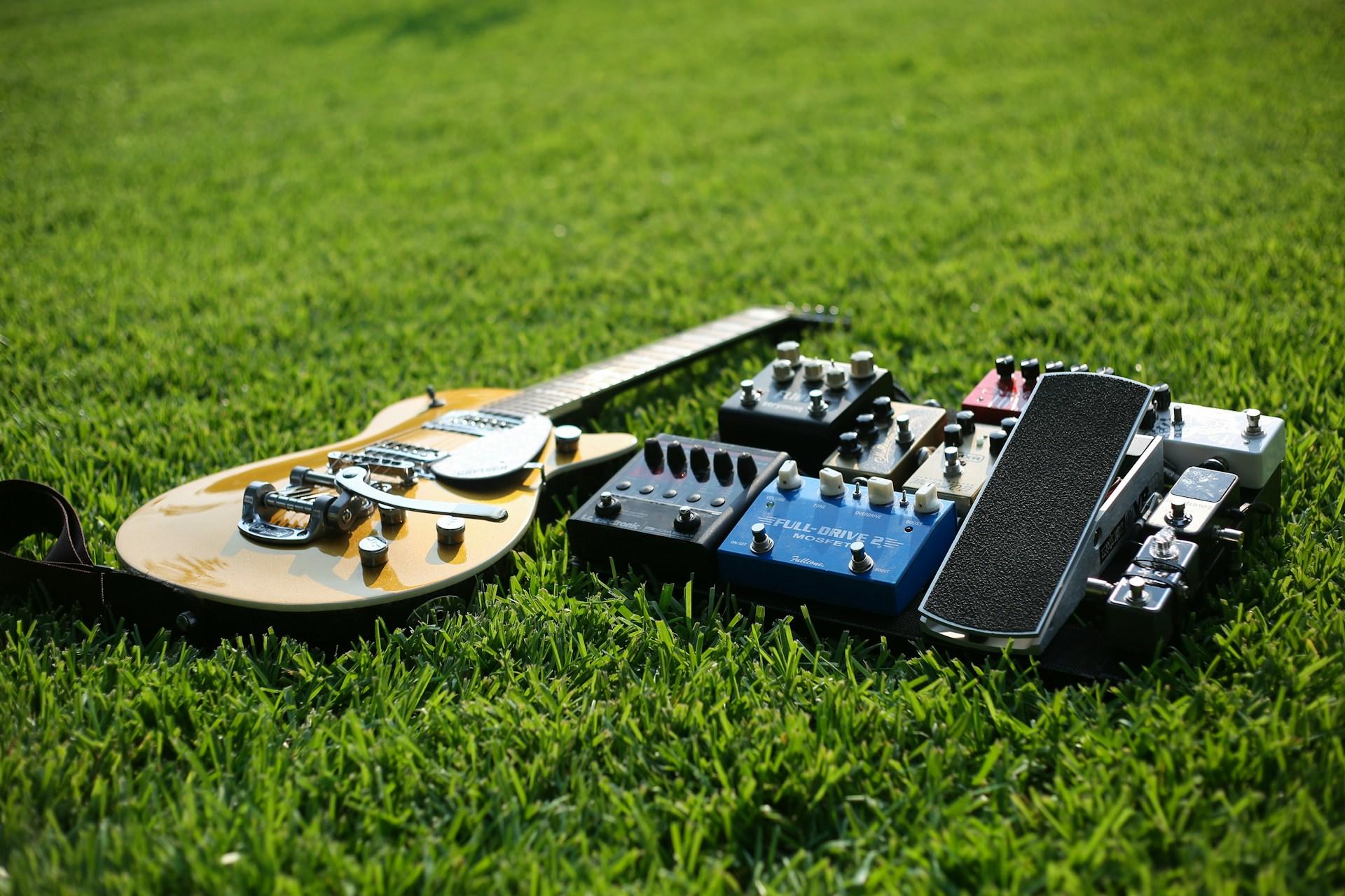 guitare posée au sol dans l'herbe