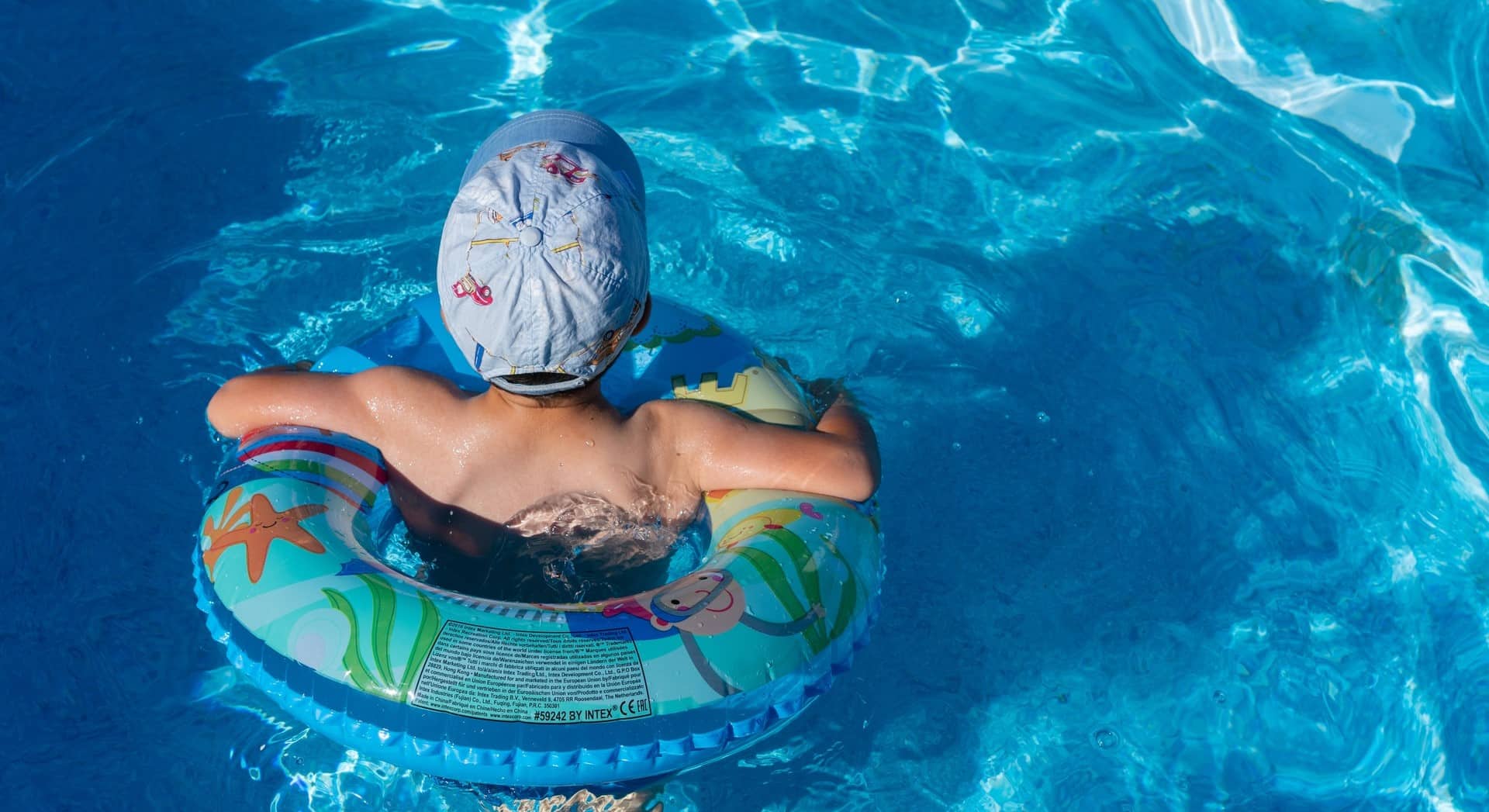 enfant avec une bouée dans un bassin à la piscine