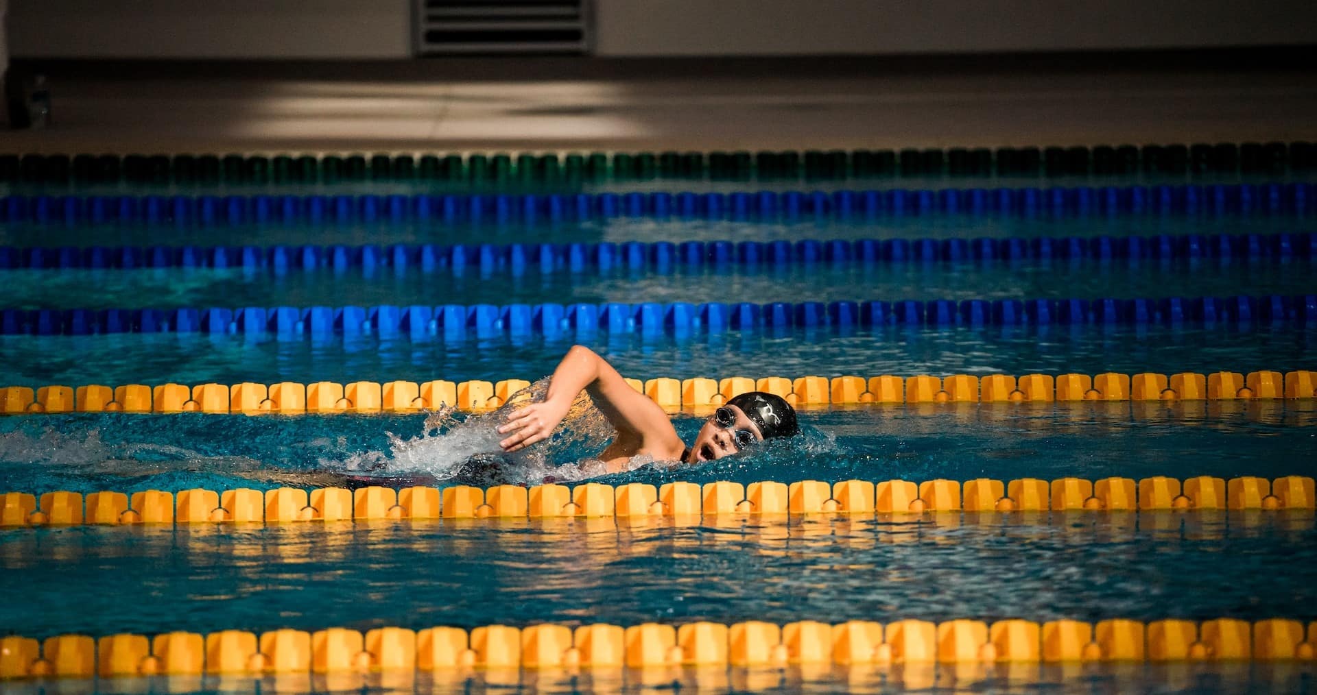 petit garçon nageant dans un couloir de piscine