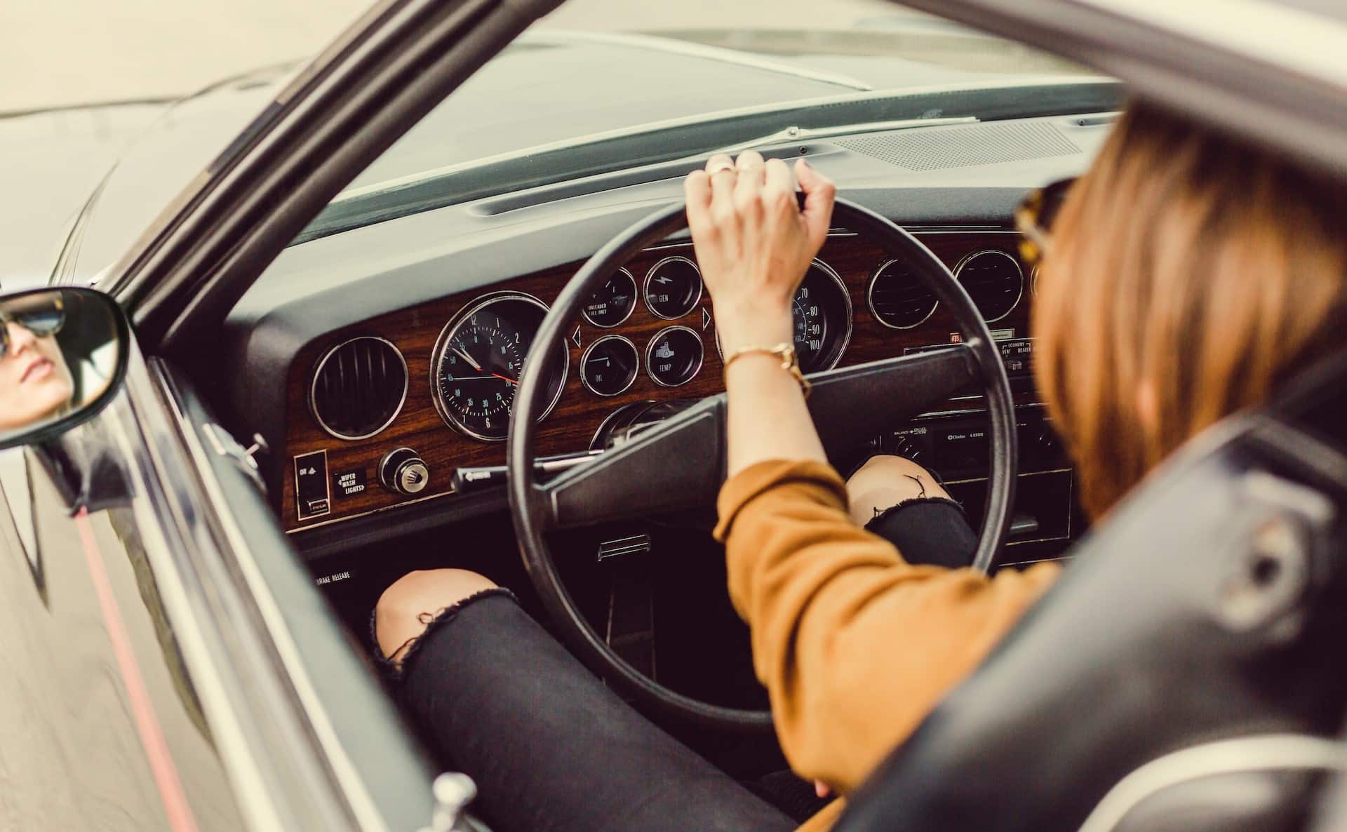 femme avec sa main gauche sur le volant