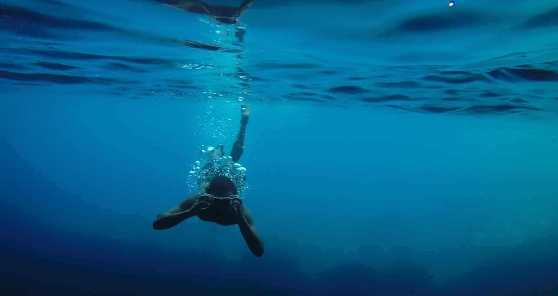 homme à l'aise dans l'eau et filmant la vie sous-marine