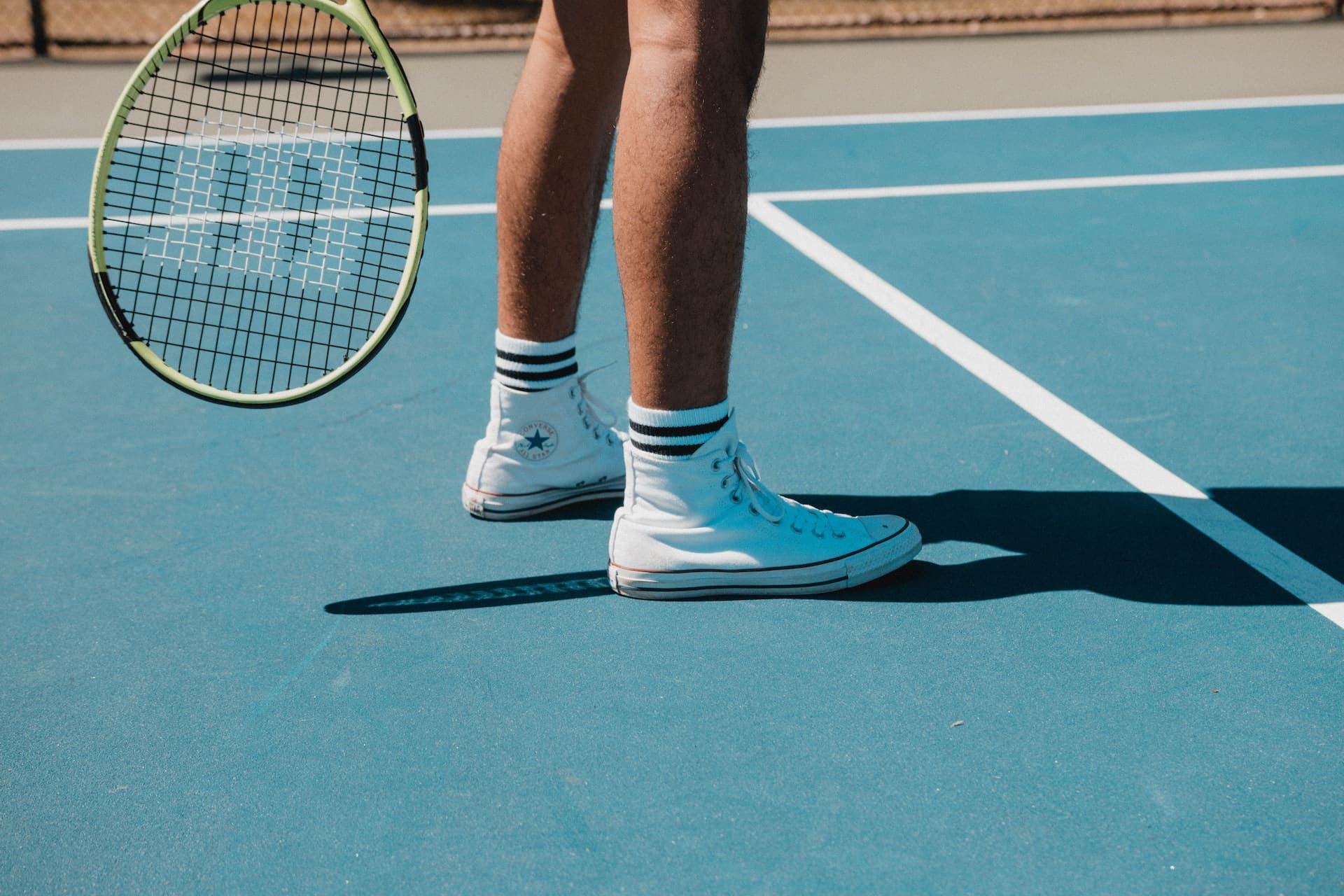 jambes d un tennisman qui tient sa raquette