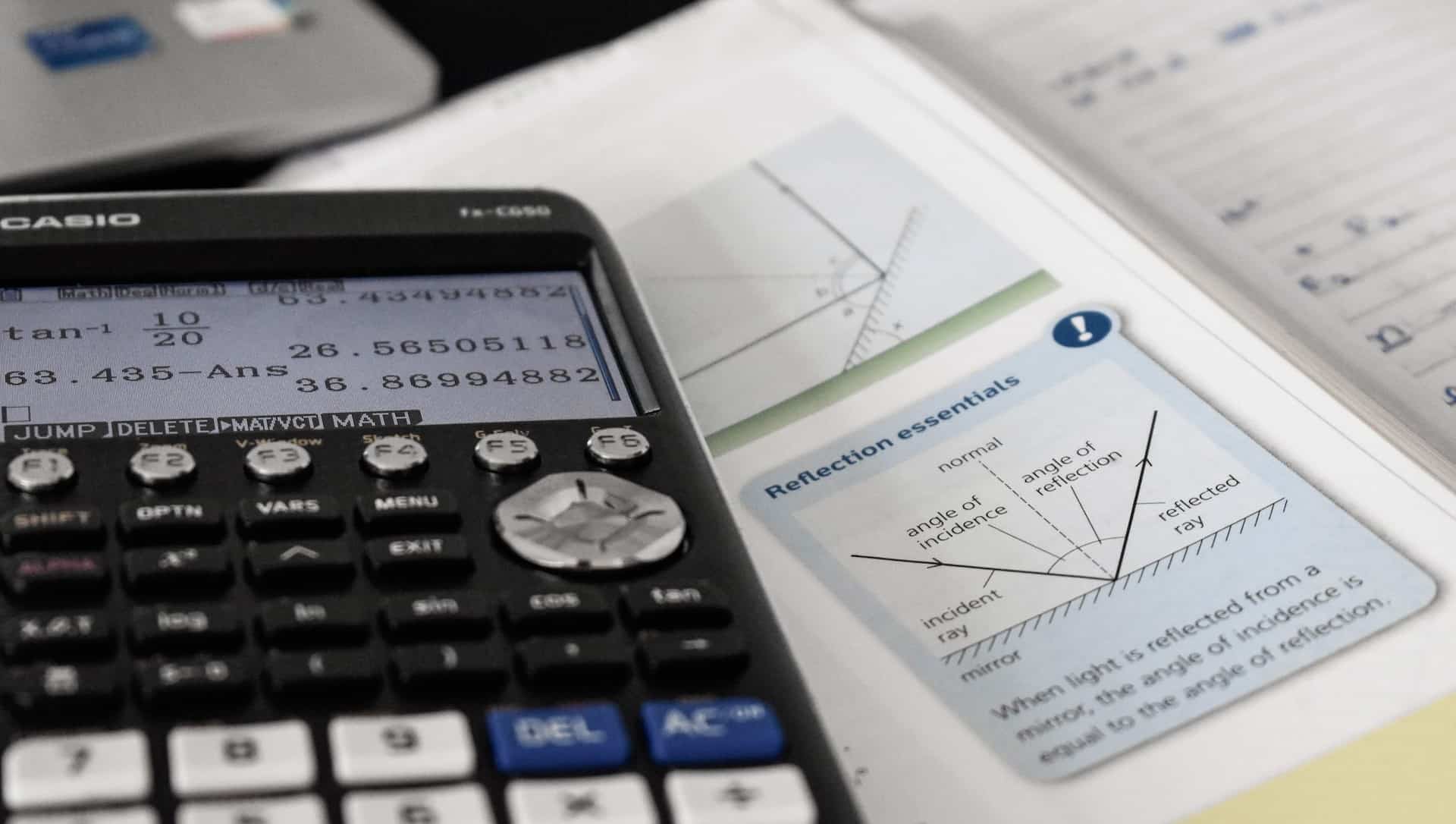 calculatrice près de courbes dans un livre de Physique