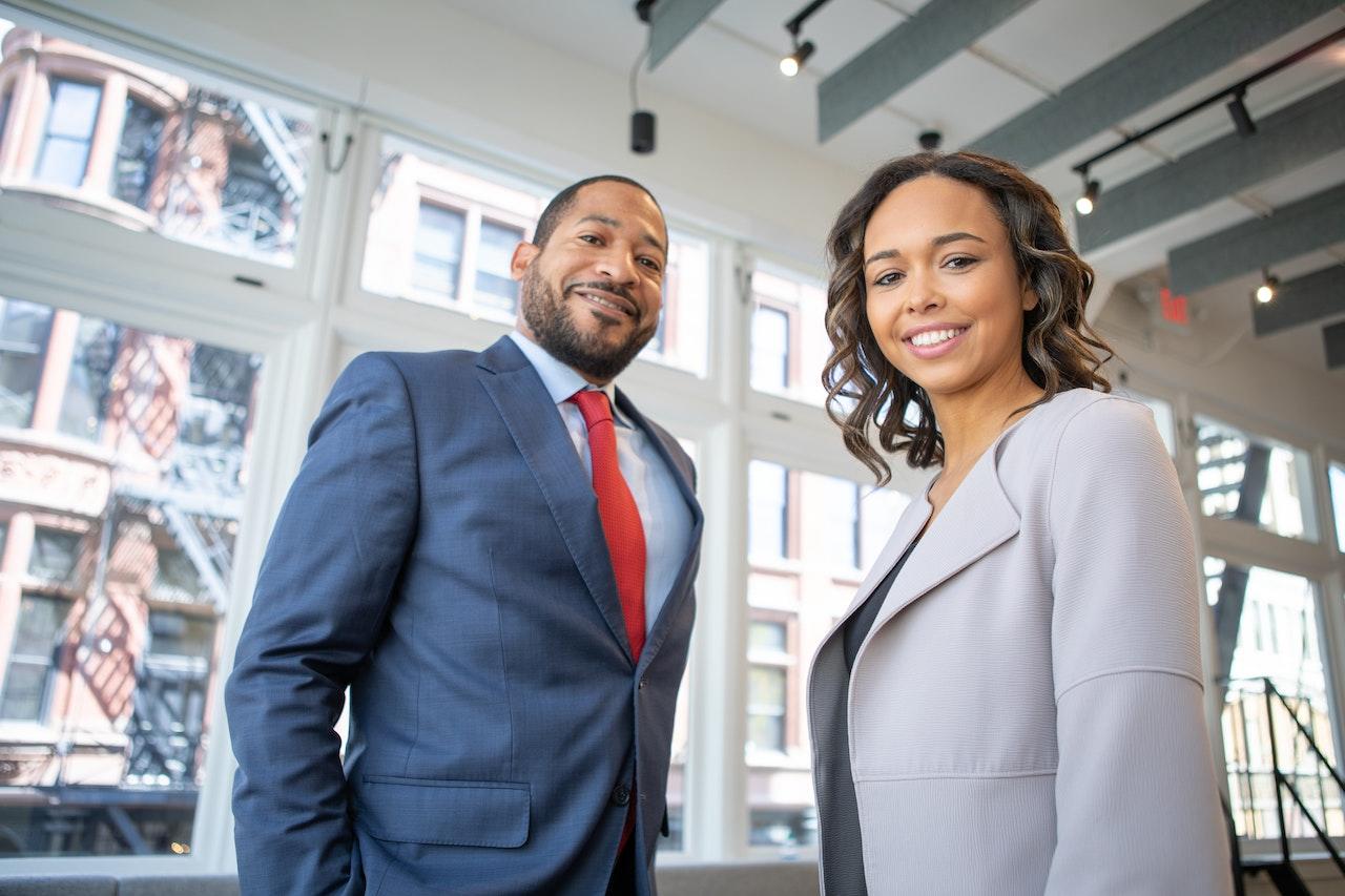 un homme et une femme en habit de travail souriant
