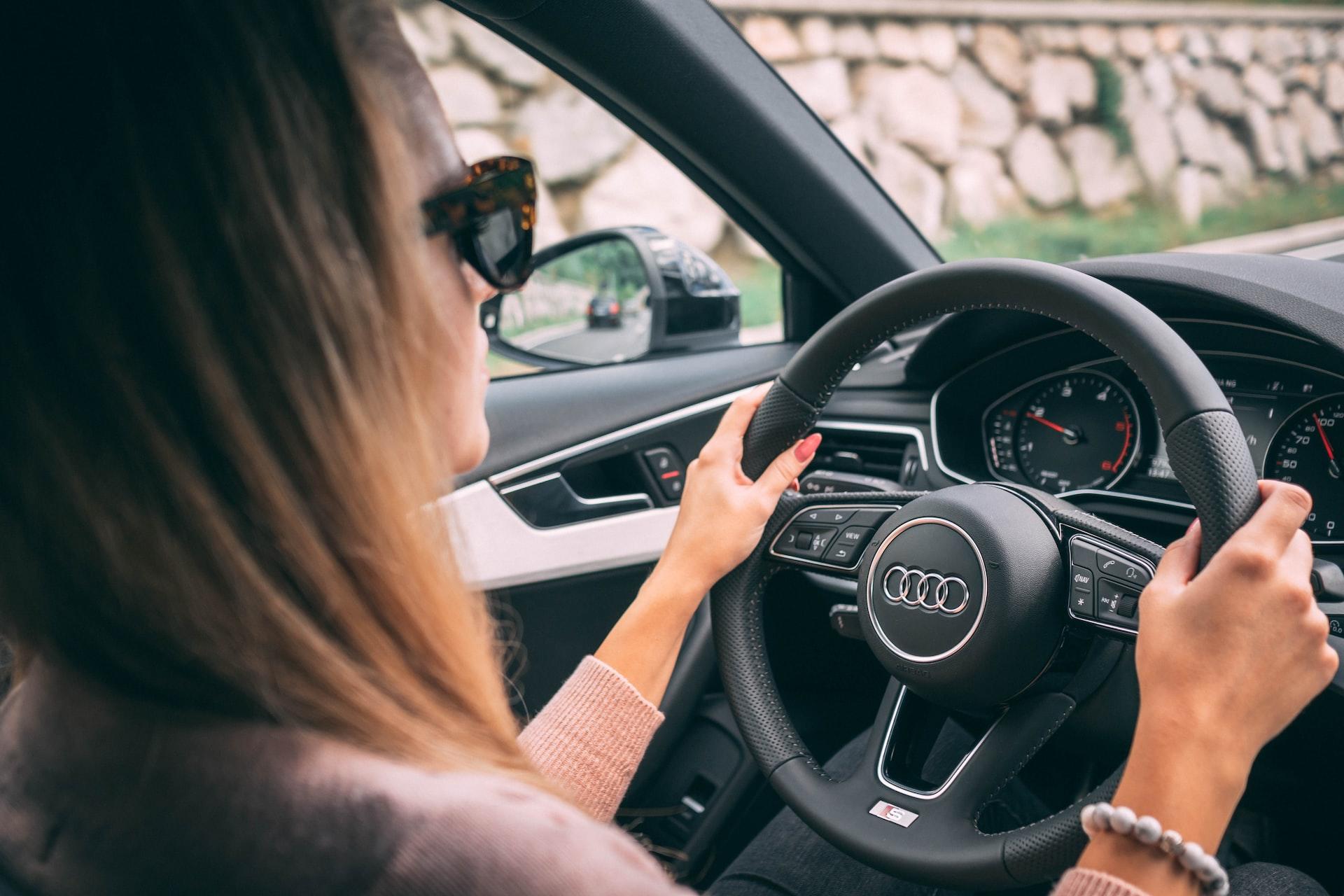 femme dans sa voiture avec lunettes de soleil
