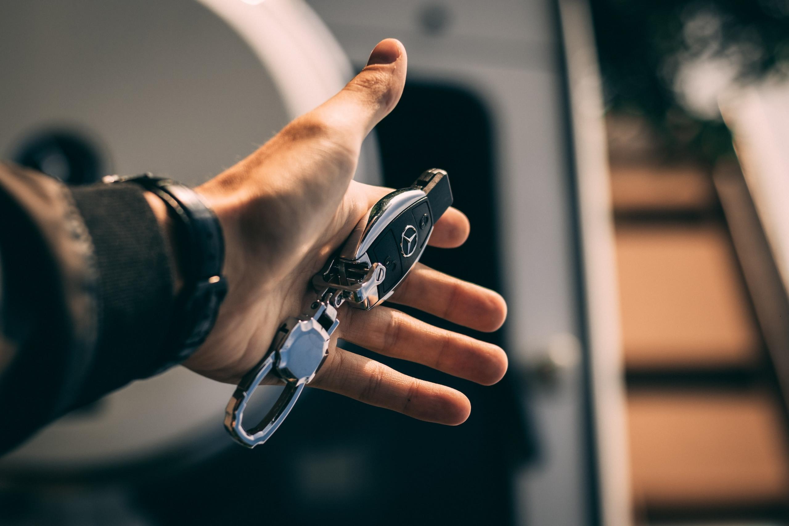 homme tenant des clés de voiture dans sa main