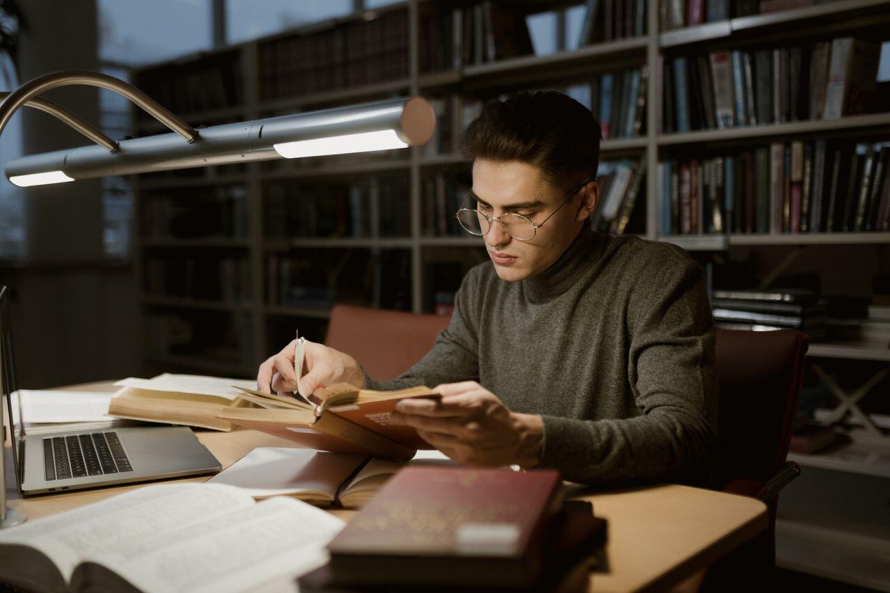 jeune en col roule etudiant a la bibliotheque