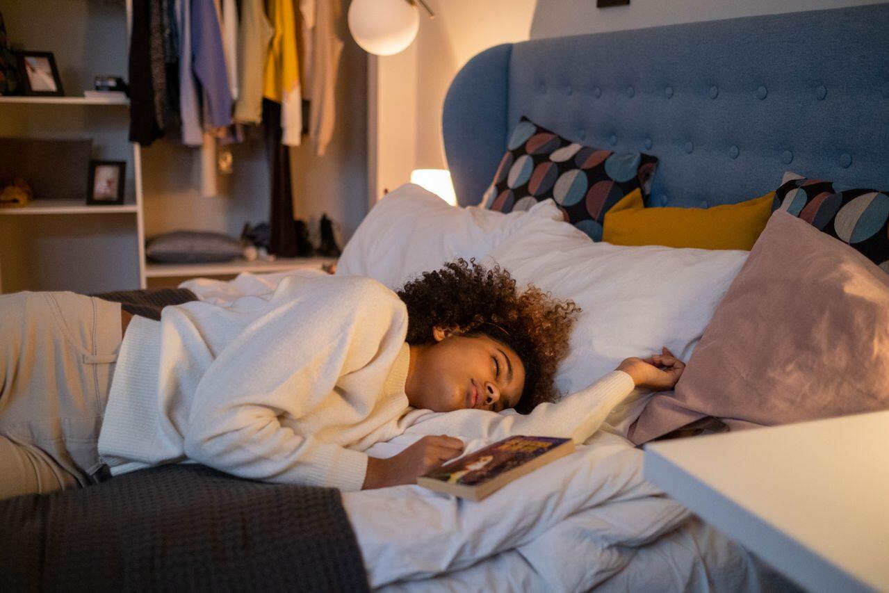 adolescente endormie dans son lit avec un livre