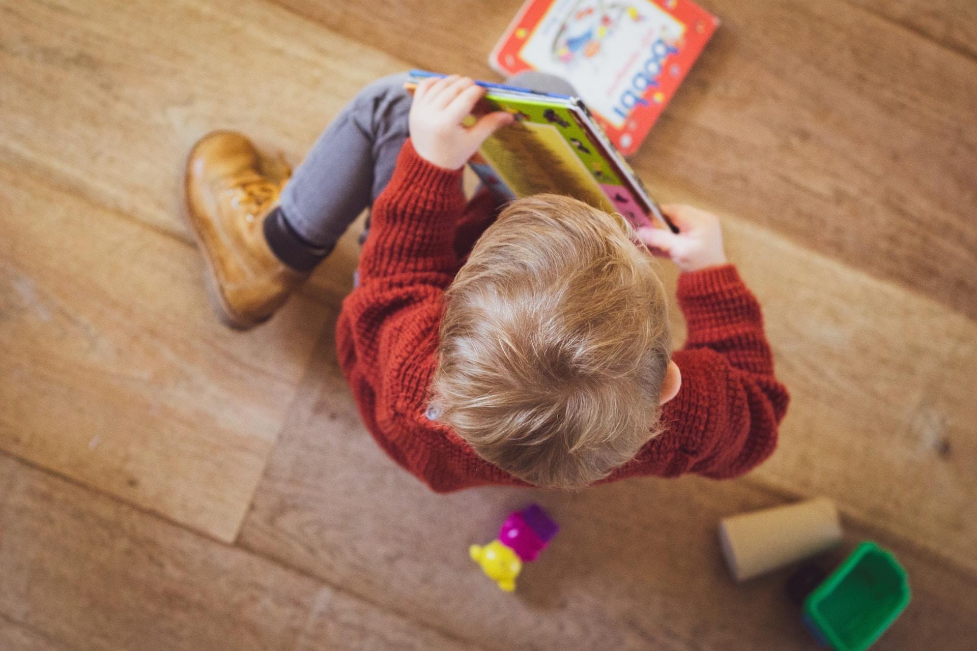 enfant petit garçon avec livres colorés