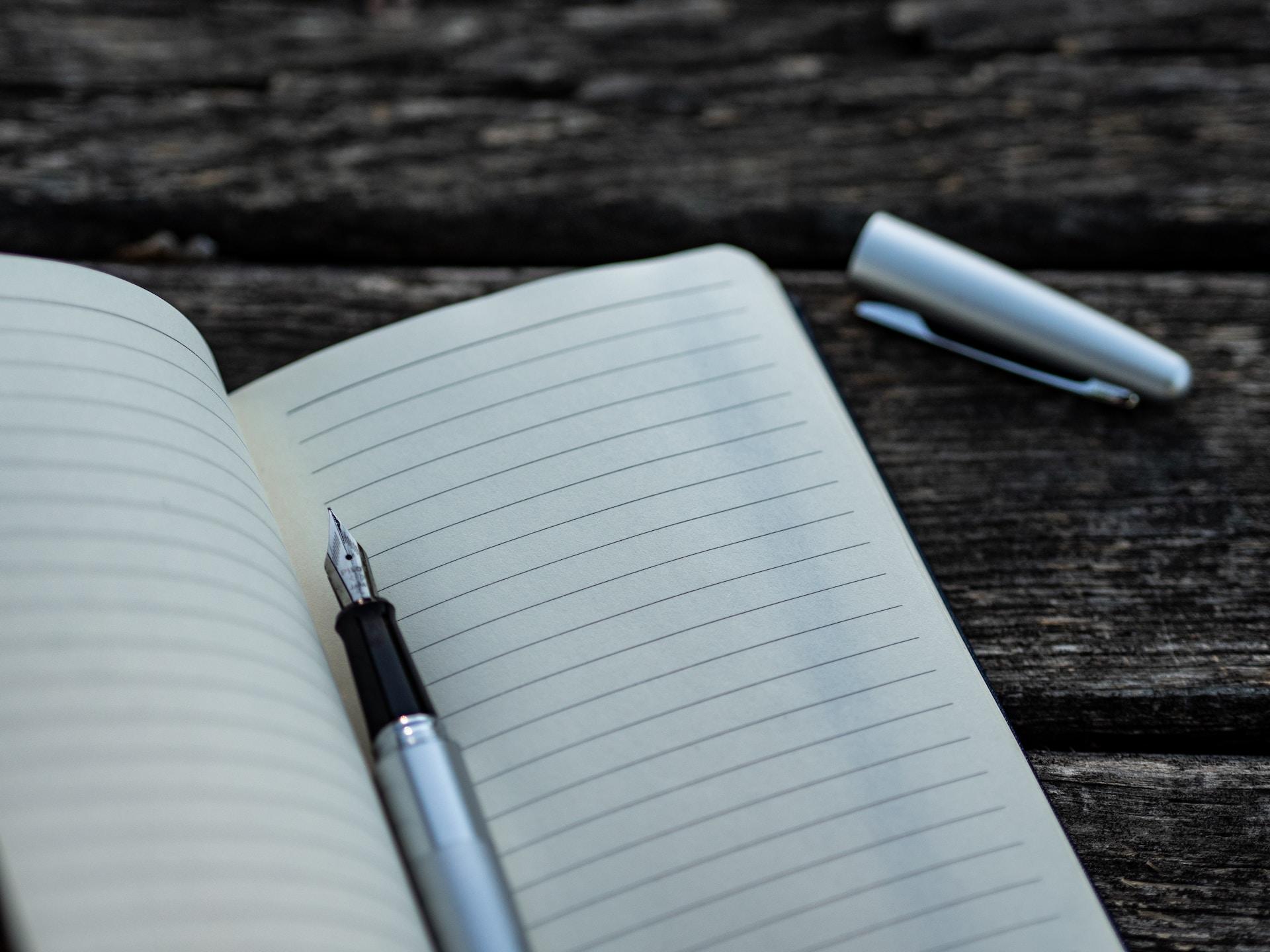 stylo posé entre deux pages d'un carnet blanc