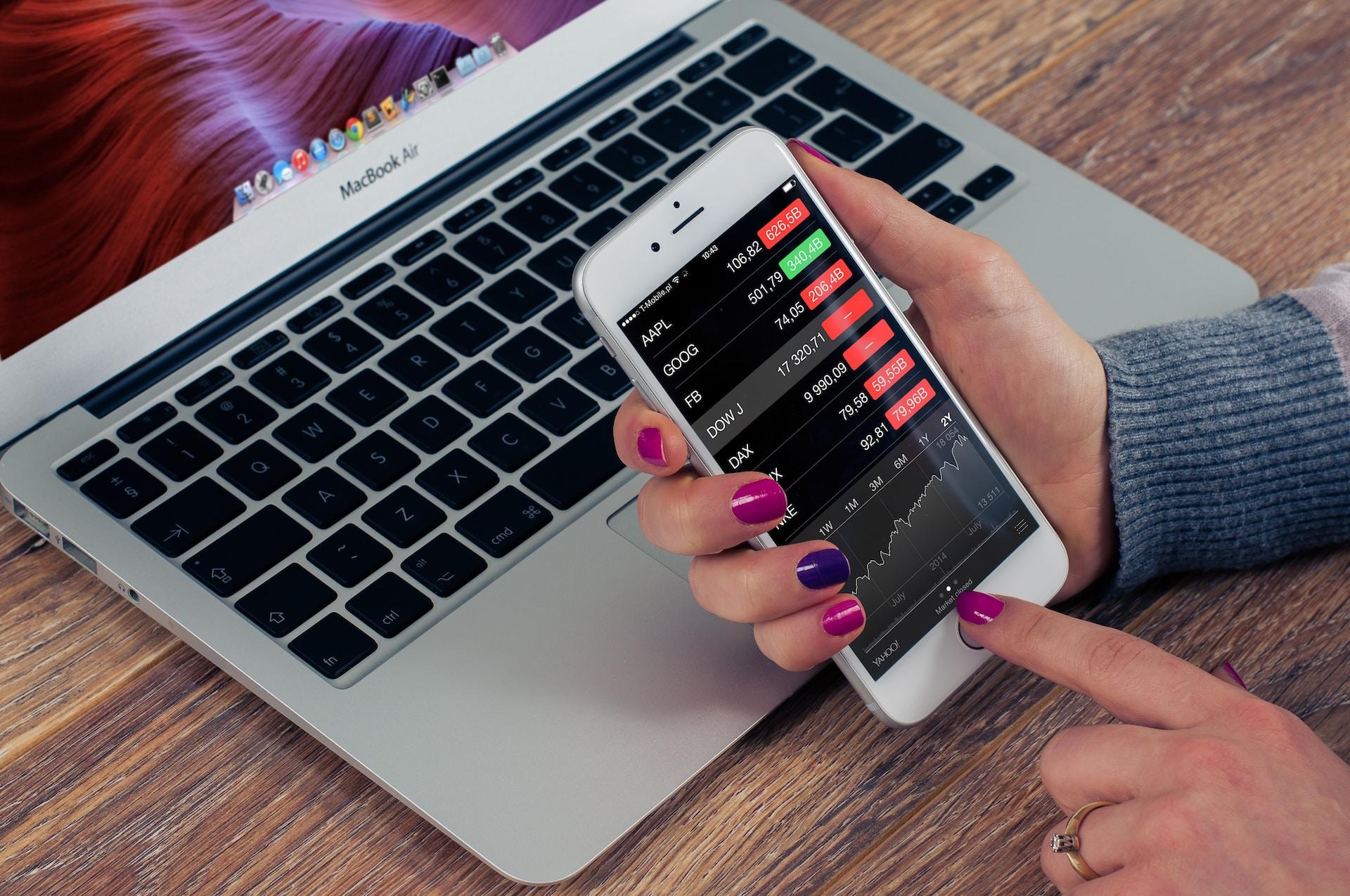 femme verifiant les actions en bourse avec son téléphone