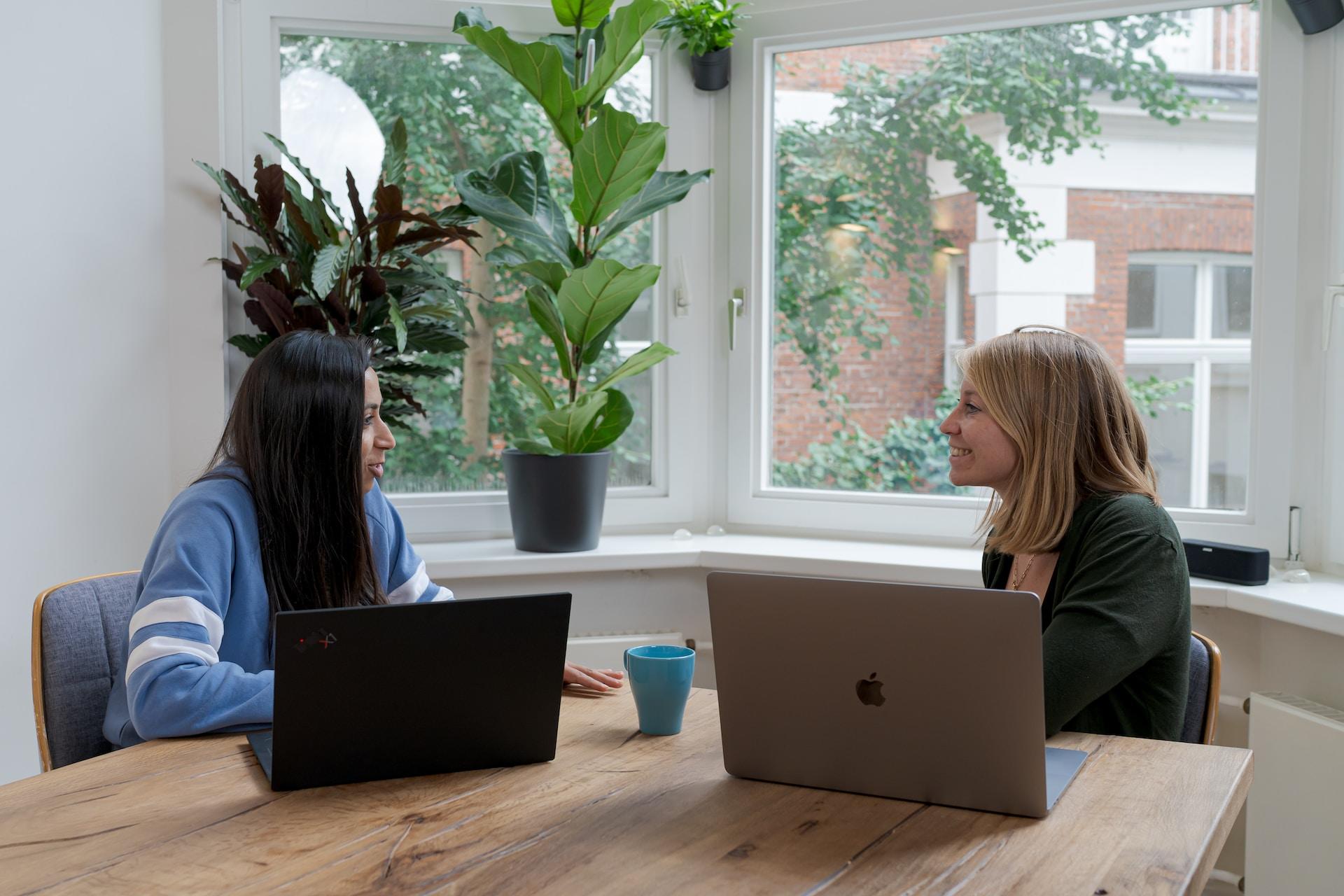 deux femmes au travail parlant ensemble avec le sourire