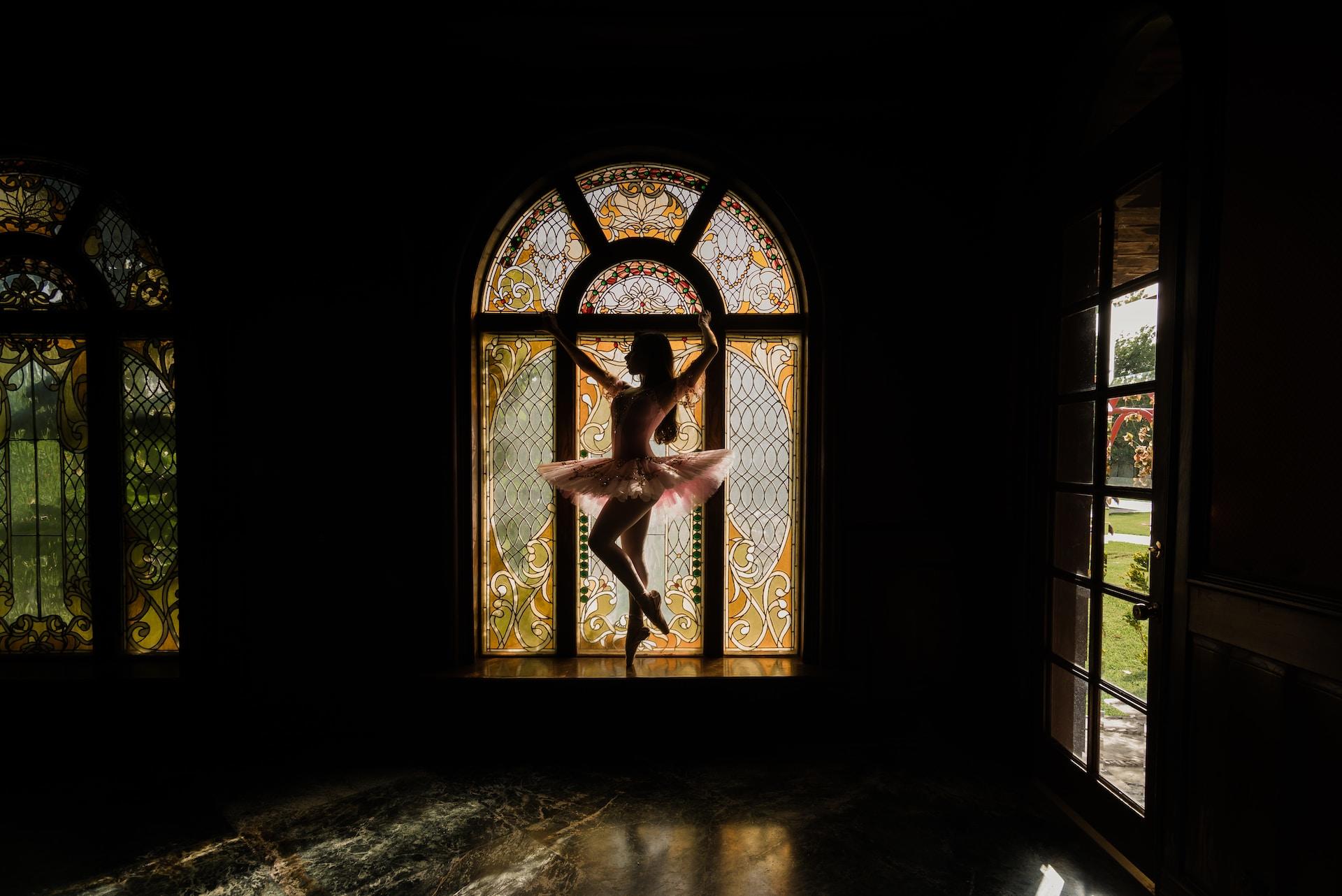 femme faisant de la danse classique devant un vitrail