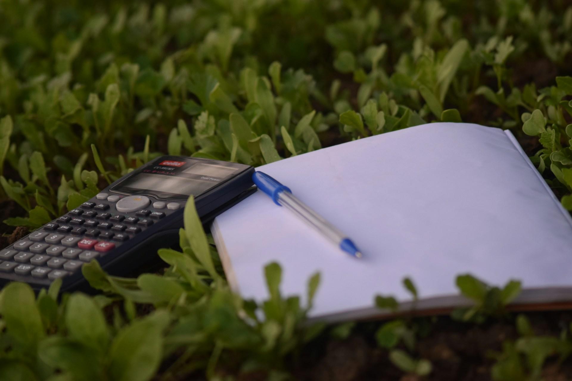 calculette et carnet dans l herbe