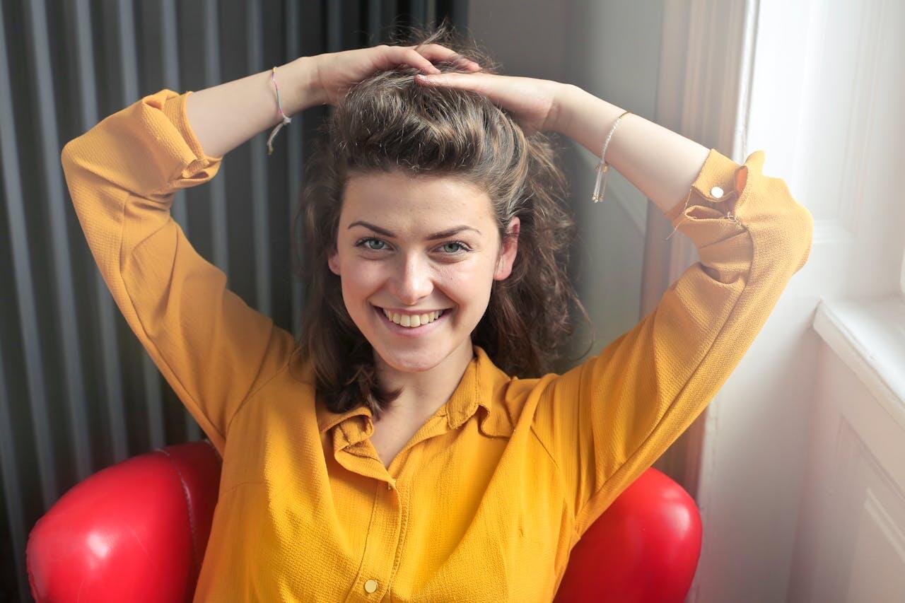 jeune femme souriant a l interieur avec chemisier jaune