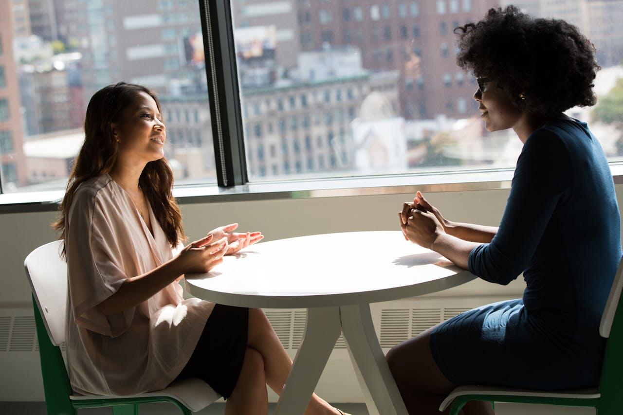 deux femmes parlant a une table