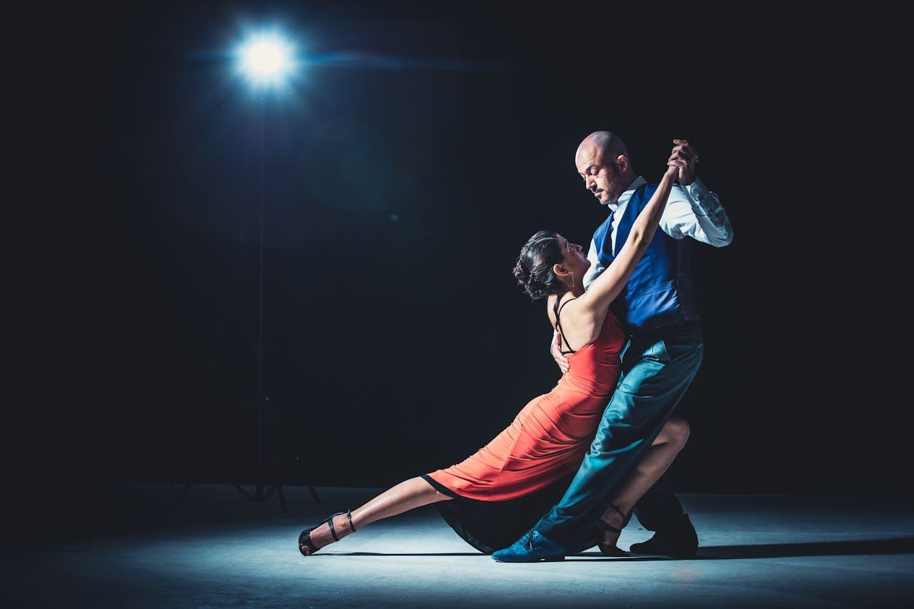 homme elegant et femme en robe rouge effectuant un tango
