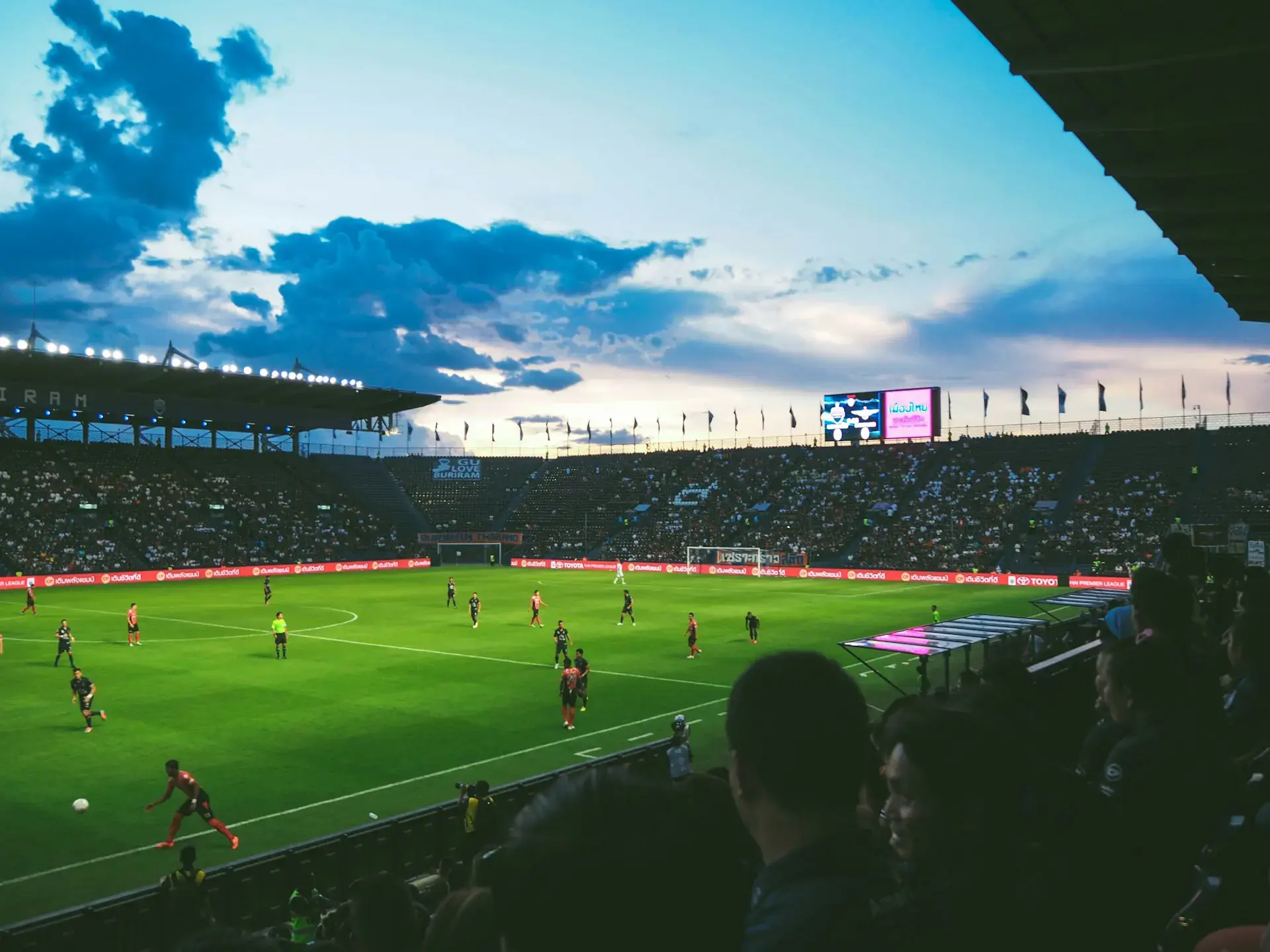 Des joueurs sur un terrain de foot avec des supporters
