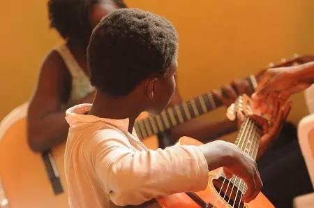 As crianças aprendem cedo a gostar de violão e de música