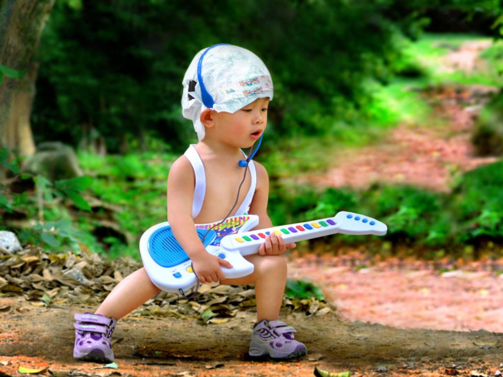 Bebé tocando guitarra de brincar.