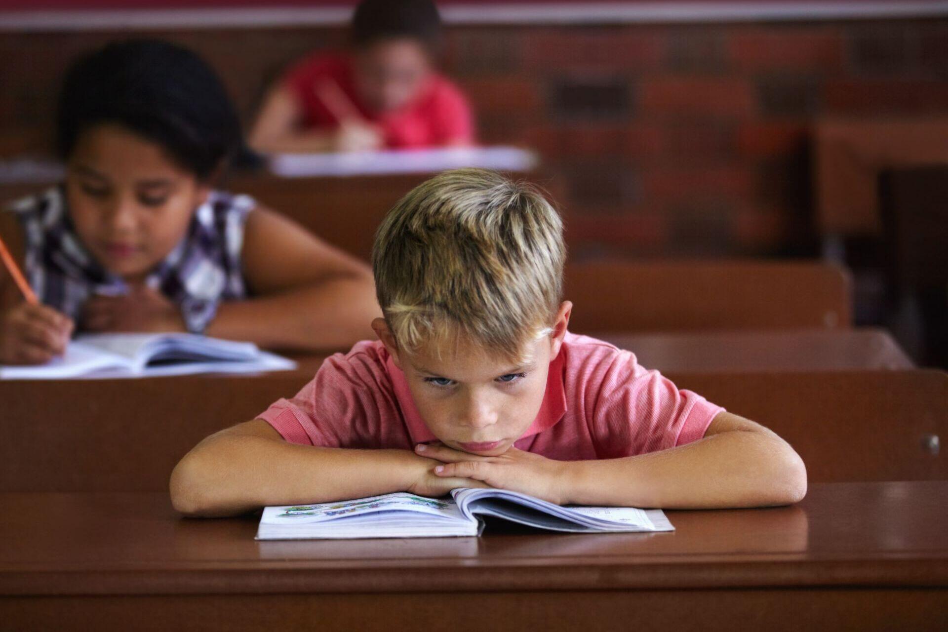 Criança aborrecida na sala de aula.