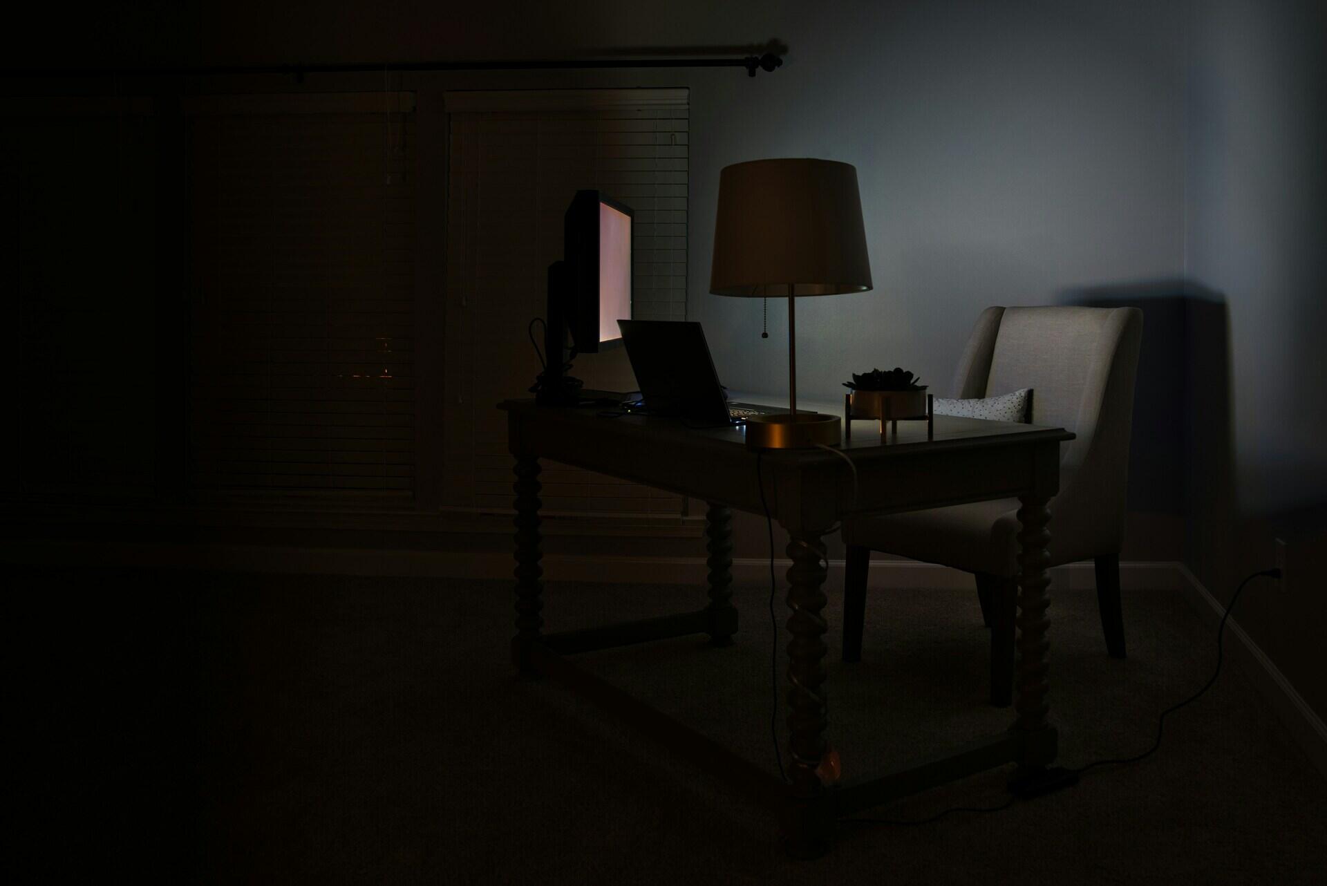 Computador iluminando um quarto escuro.