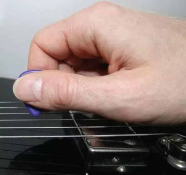 Tocar violão com uma mão utilizando uma palheta.