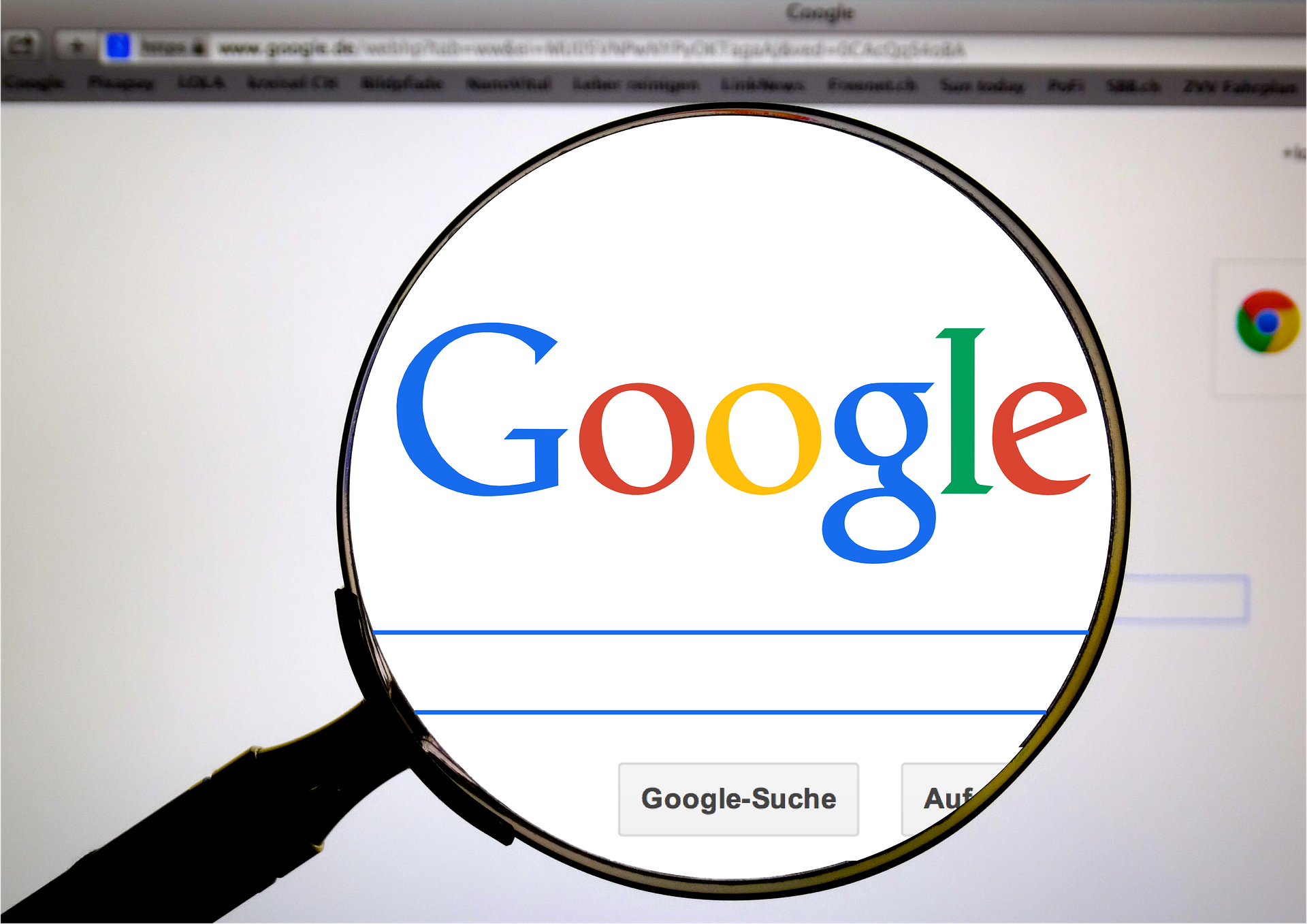 Uma lupa aumenta a tela do computador onde lemos "Google"