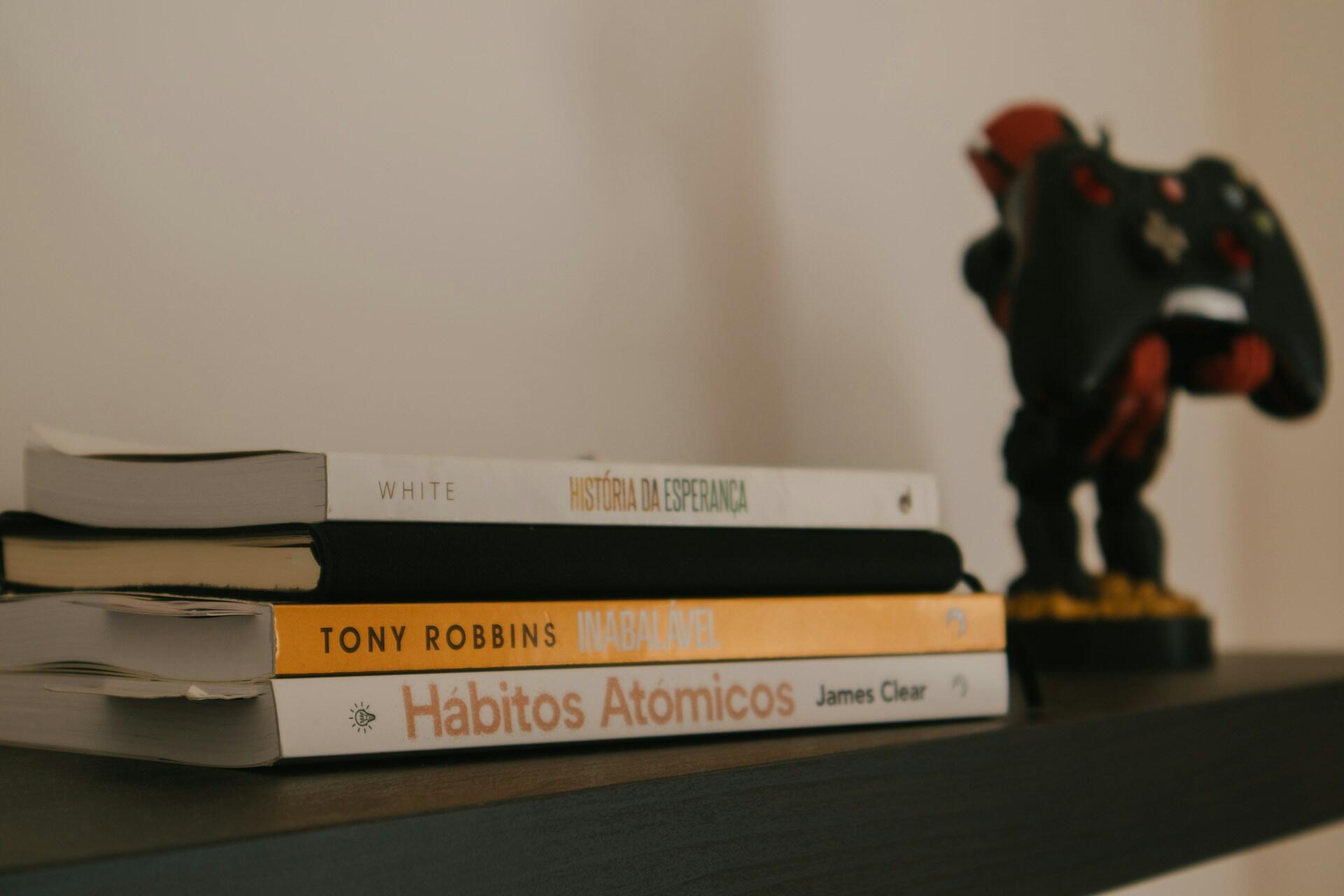 Livros empilhados em uma prateleira.