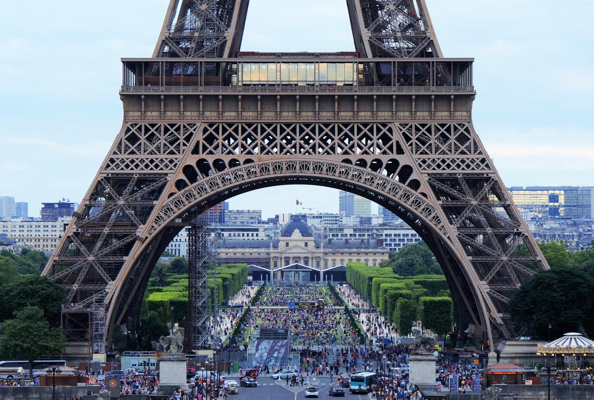 Foto da cidade vista pelo arco que se forma no pé da Torre Eiffel.