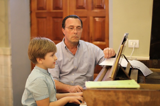 Professor e aluno criança durante aula de piano.