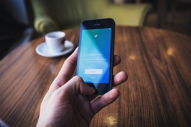 Smartphone: mão segurando celular em uma mesa de café