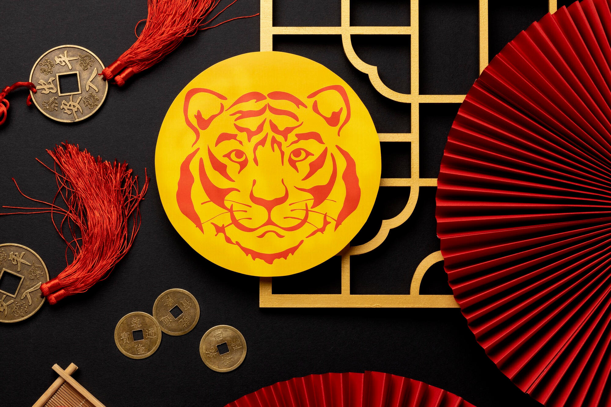 Imagem do tigre do zodíaco chinês em cima da mesa com outros itens da cultura da China.
