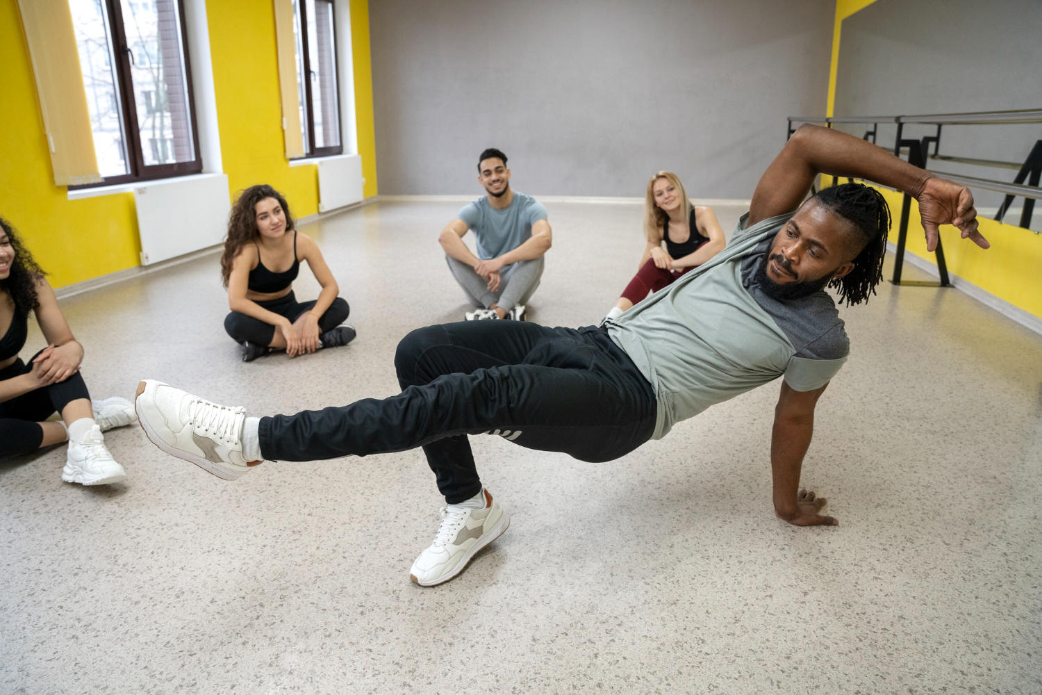 Professor ensinando dança para os alunos no estúdio.