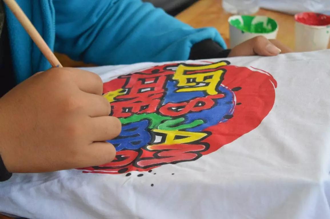 Criança pintando uma camiseta.